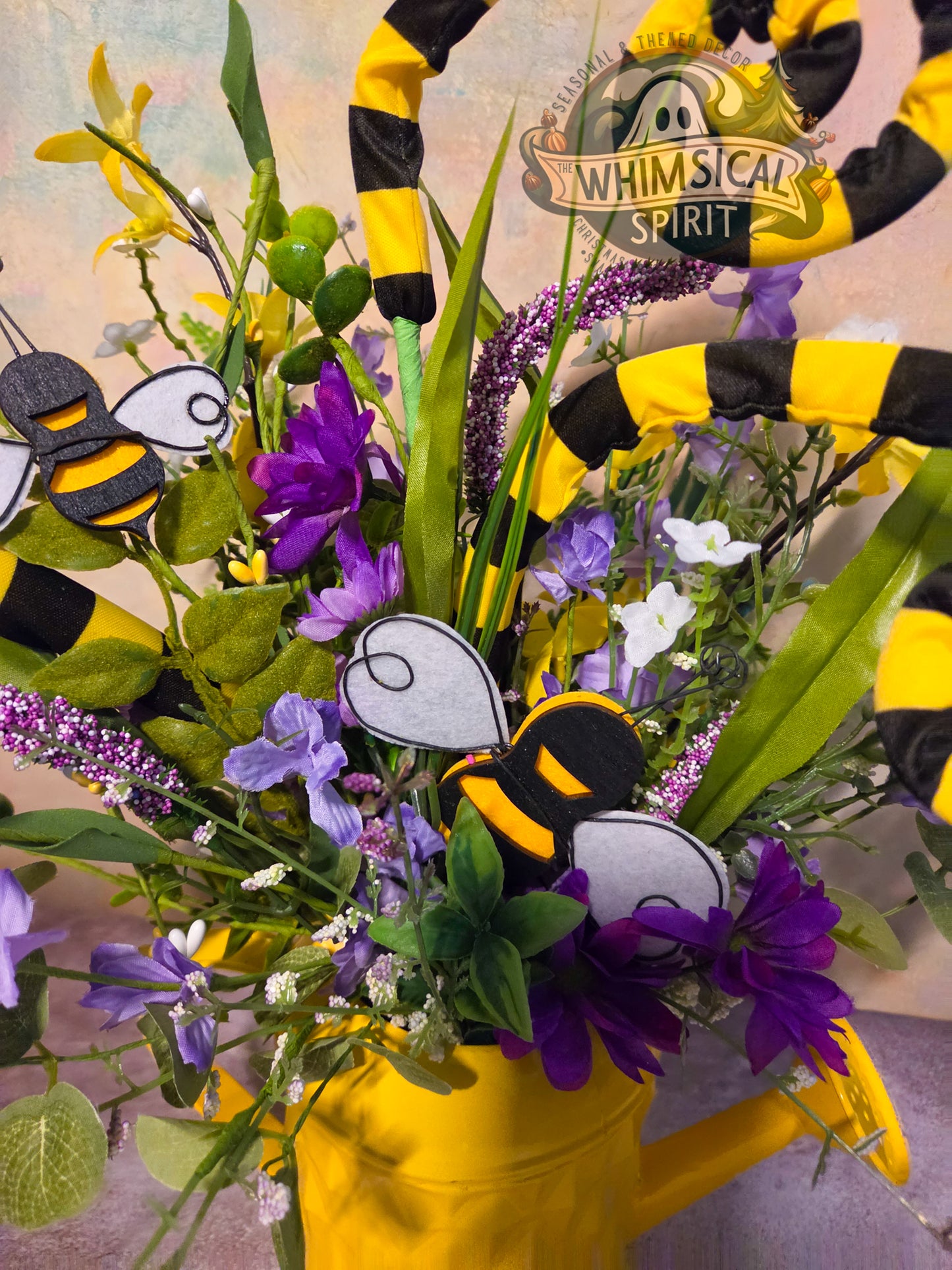 Bouquet of flowers with bee decorations and a 'Whimsical Spirit' sign in the background.
