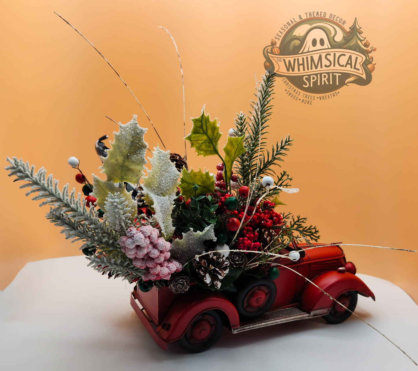 Festive red car decoration with greenery and berries, Christmas-themed arrangement by Whimsical Spirit adding holiday charm