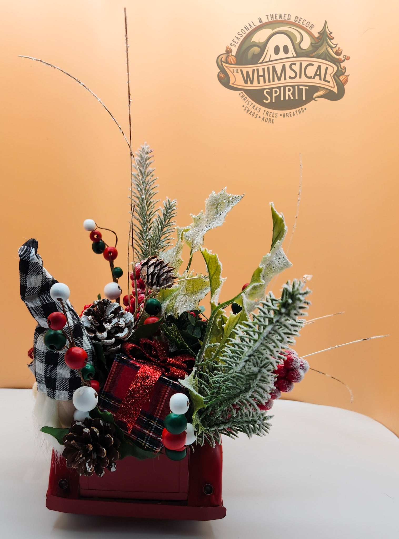 Whimsical Spirit decorative floral arrangement with pine cones and red berries on a white surface, perfect for a festive Christmas display