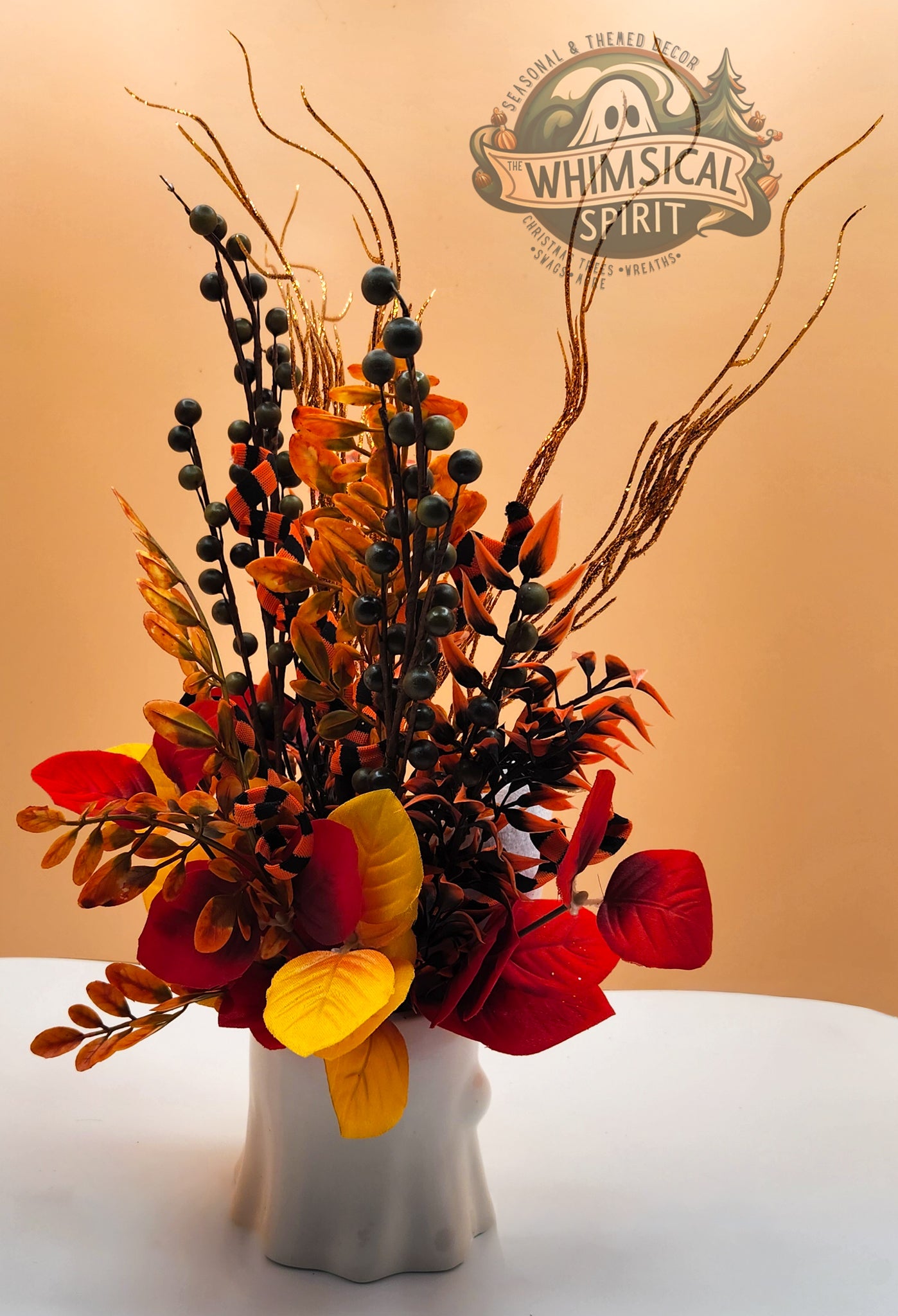 Autumn-themed floral arrangement in a white vase with 'Whimsical Spirit' logo in the corner.