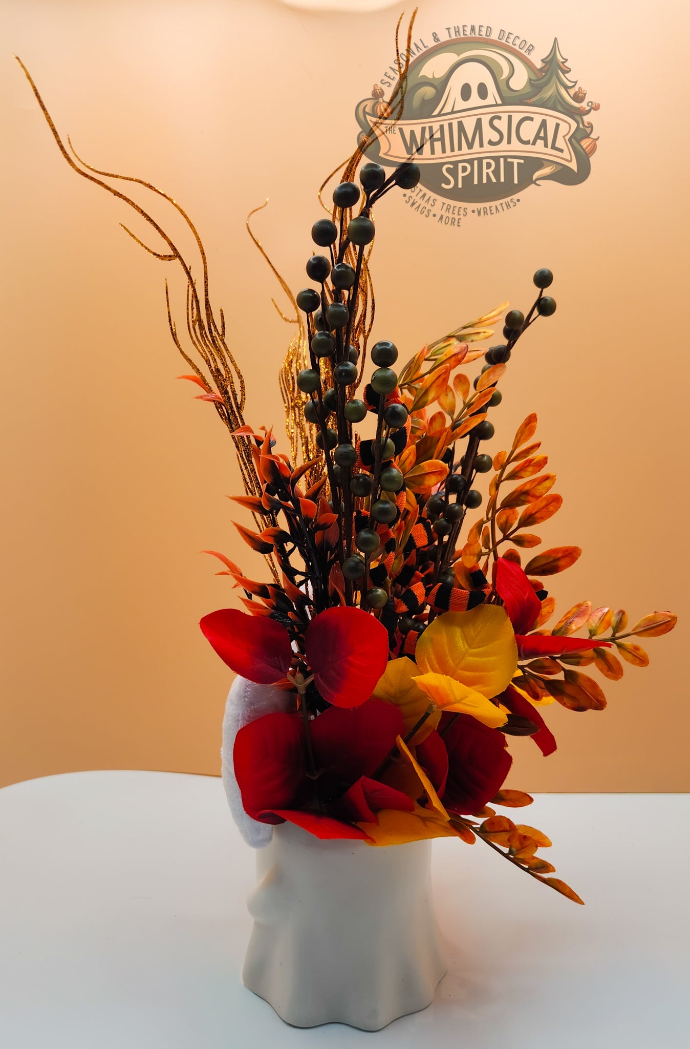 Decorative Fall floral arrangement in a white vase with 'Whimsical Spirit' branding in the background.