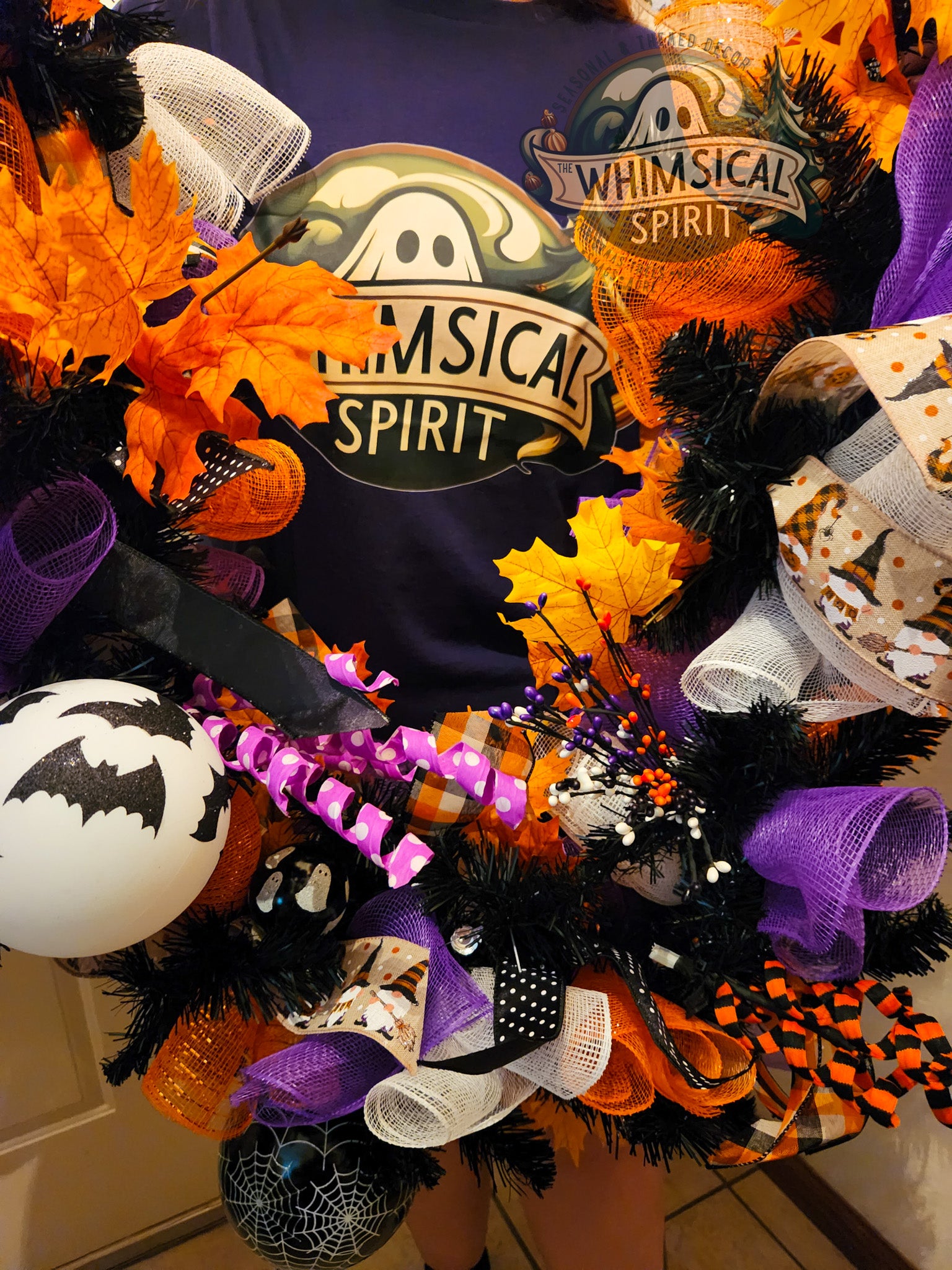 Halloween-themed wreath with decorative elements and Whimsical Spirit logo in background