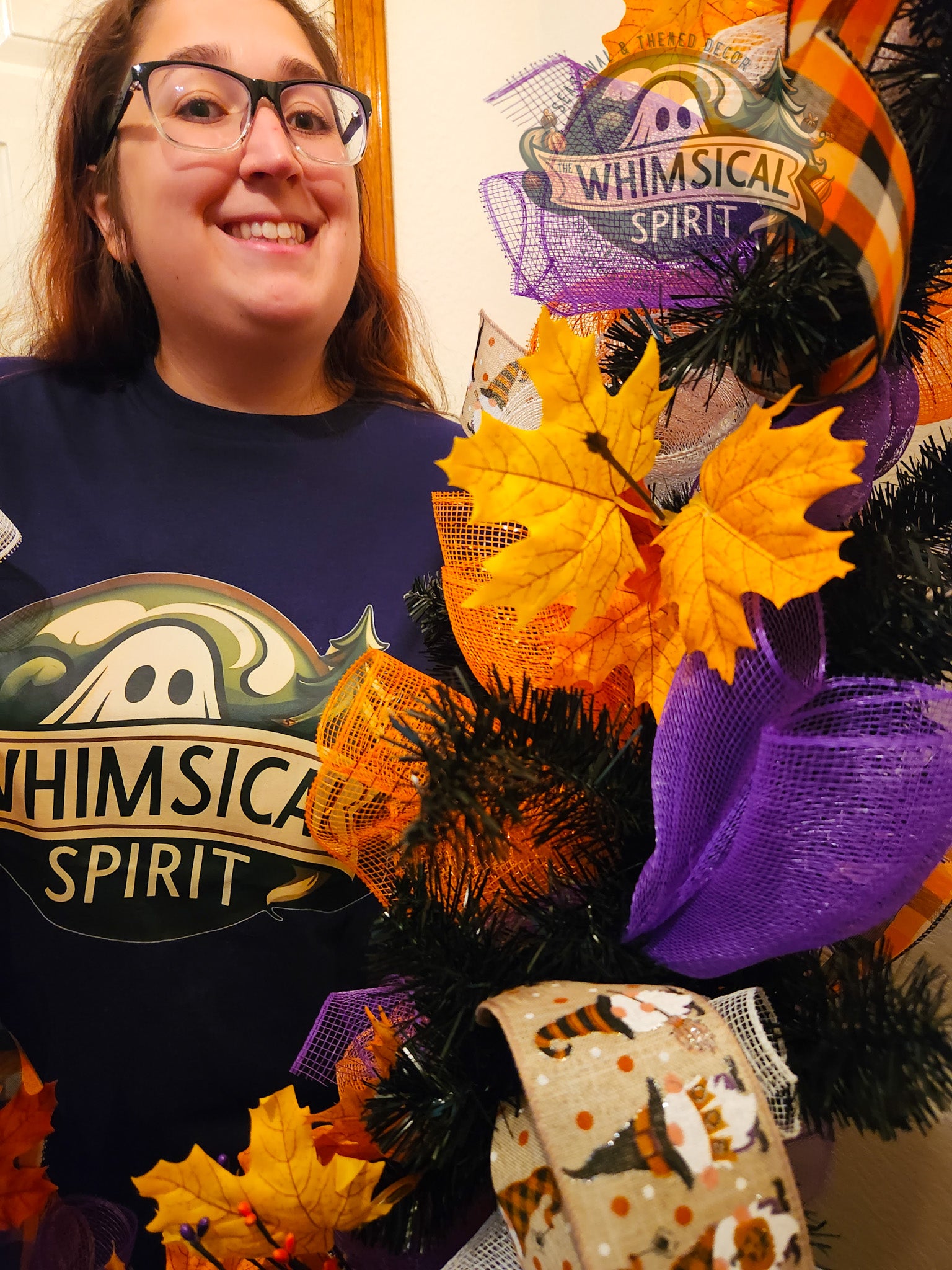 Person wearing a shirt with 'Whimsical Spirit' design next to a Halloween-themed wreath.