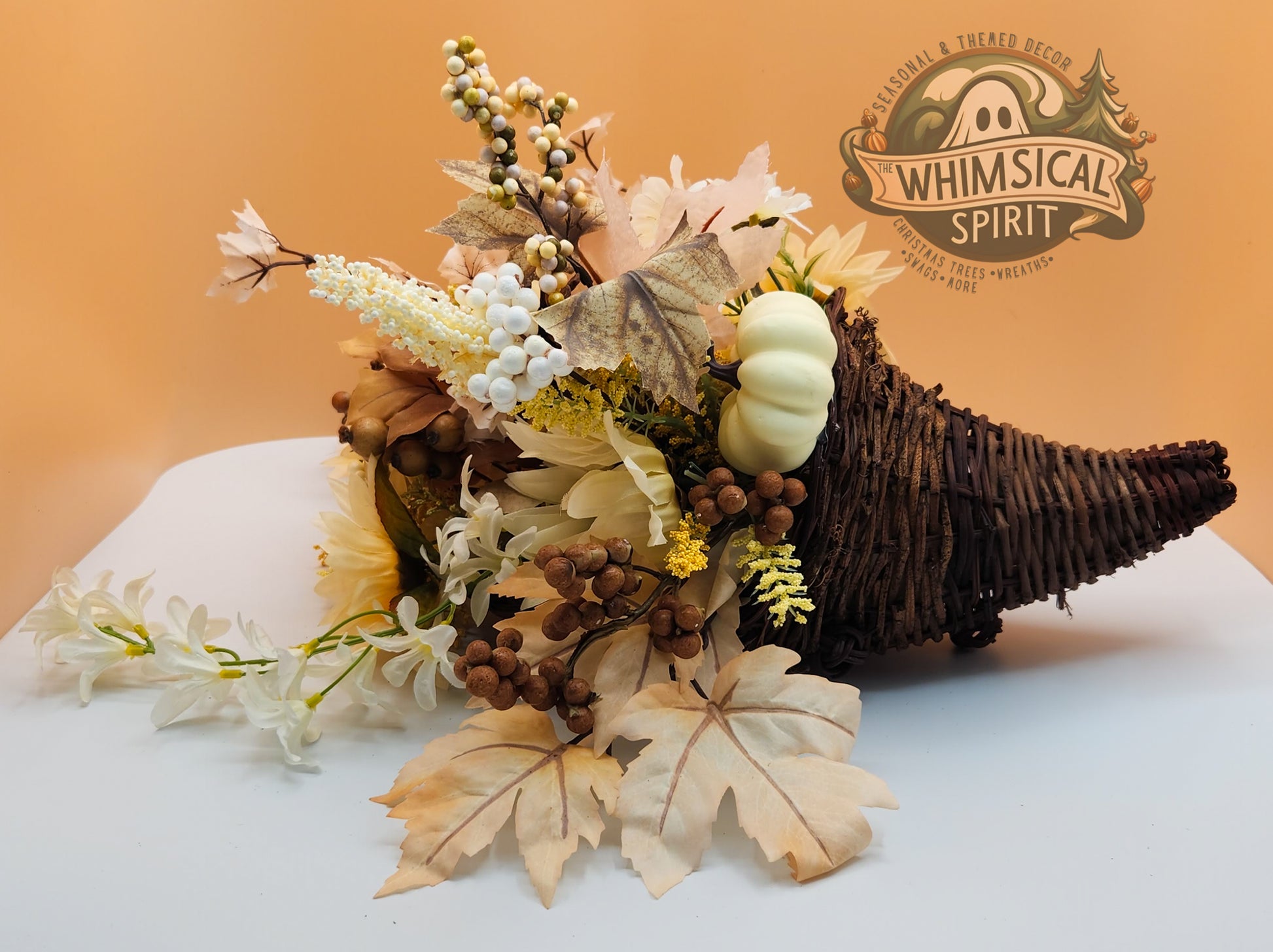 Rustic Grace cornucopia with cream flowers, leaves, natural foliage, and berries on a white surface for seasonal décor with Whimsical Spirit branding