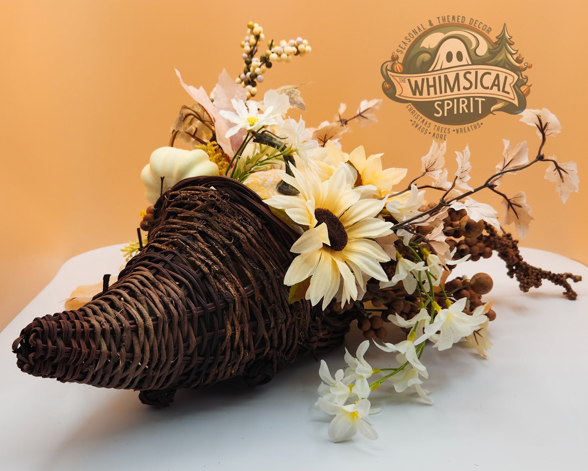 Rustic Grace decorative cornucopia with cream flowers, natural foliage, and earthy accents on a white surface, with Whimsical Spirit branding.