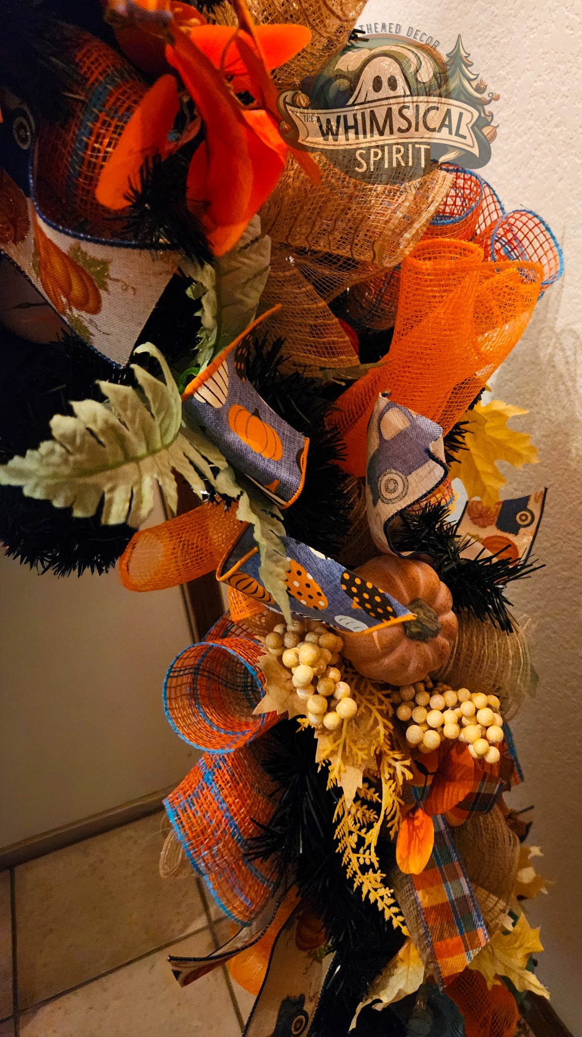 Decorative wreath with autumn-themed elements and 'Whimsical Spirit' sign.