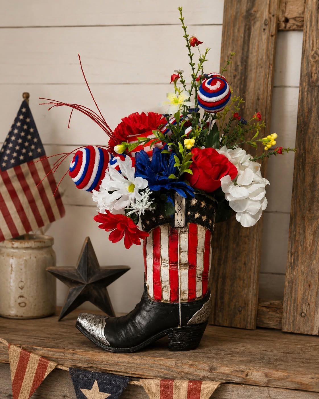 Patriotic boot floral arrangement with red, white, and blue flowers, ribbon picks, and rustic Americana decor for summer holiday styling.