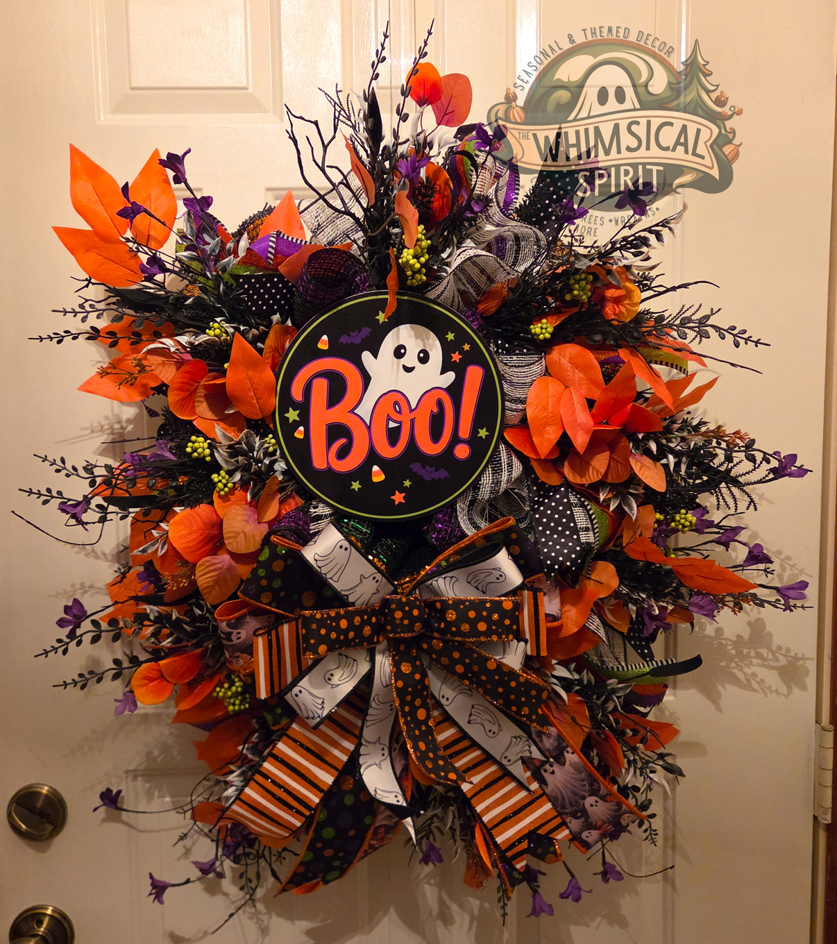Extra-large Halloween ghost wreath with a Boo sign, orange leaves, purple florals, black branches, patterned ribbon, and an oversized bow.