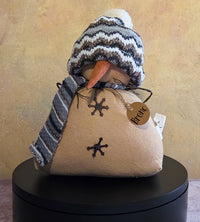 Bronc the Snowman winter soft sculpture shelf sitter with knit hat, striped scarf, carrot nose, stitched snowflake details, and name tag.