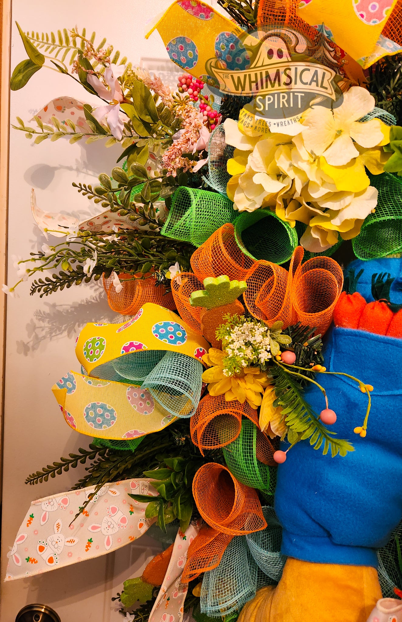 Colorful wreath with flowers and ribbons on a door