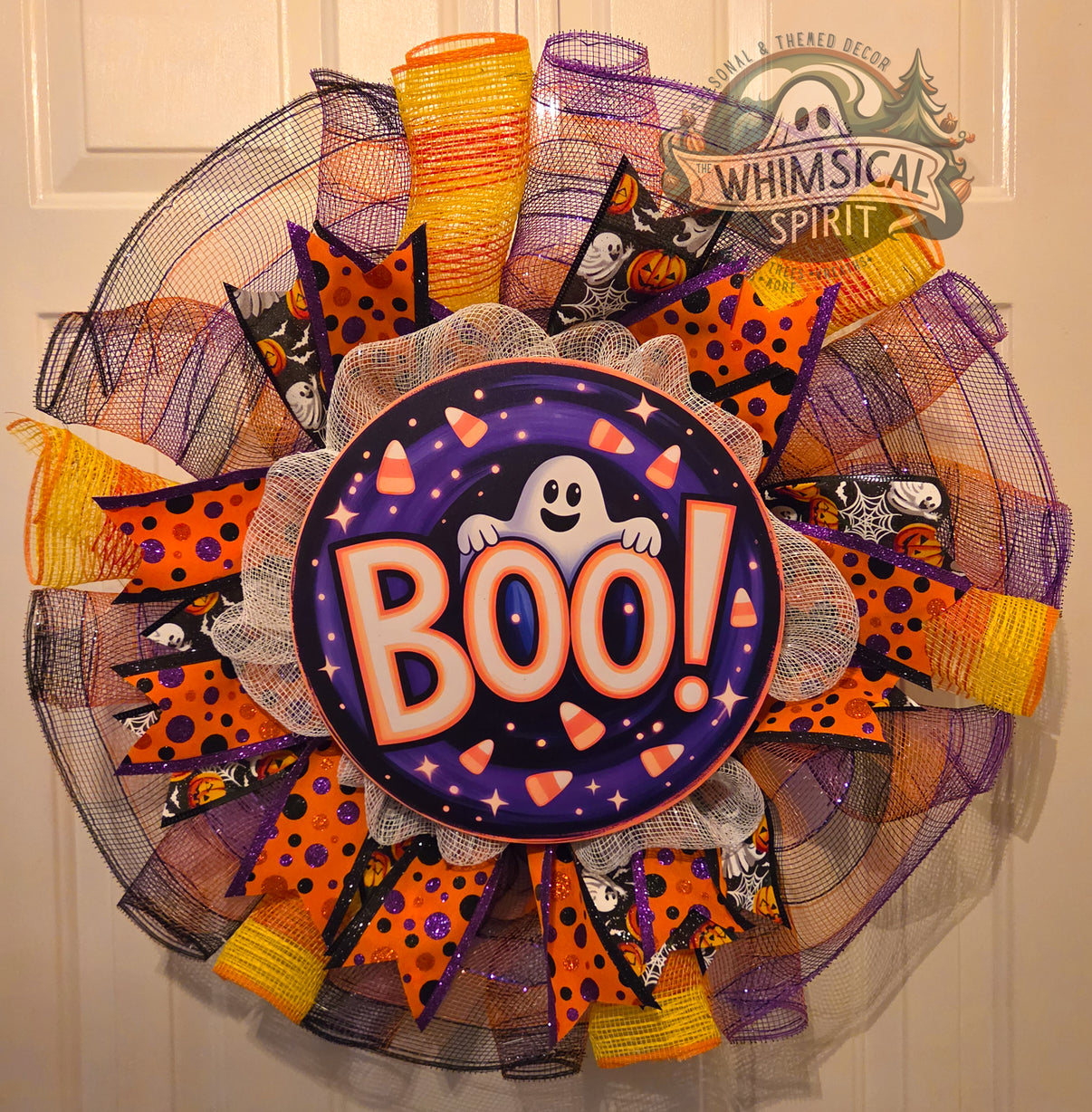 Candy Corn Commotion Halloween mesh wreath with a smiling ghost BOO! sign, candy corn, and colorful layered ribbons.