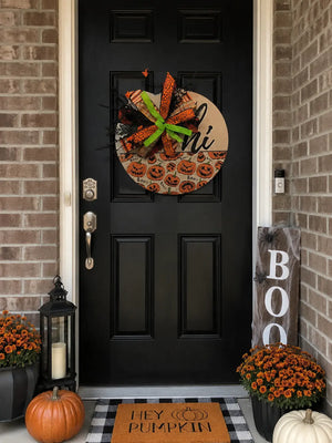 Handmade fall door hanger styled on a front door with seasonal porch decor and Halloween accents
