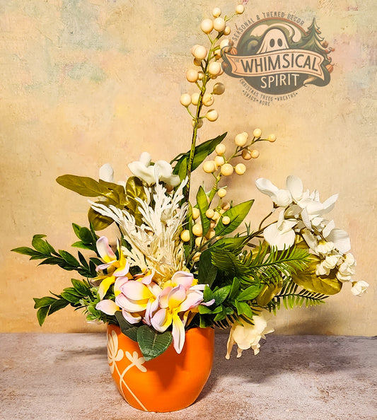 Floral arrangement in an orange vase with 'Whimsical Spirit' logo in the background
