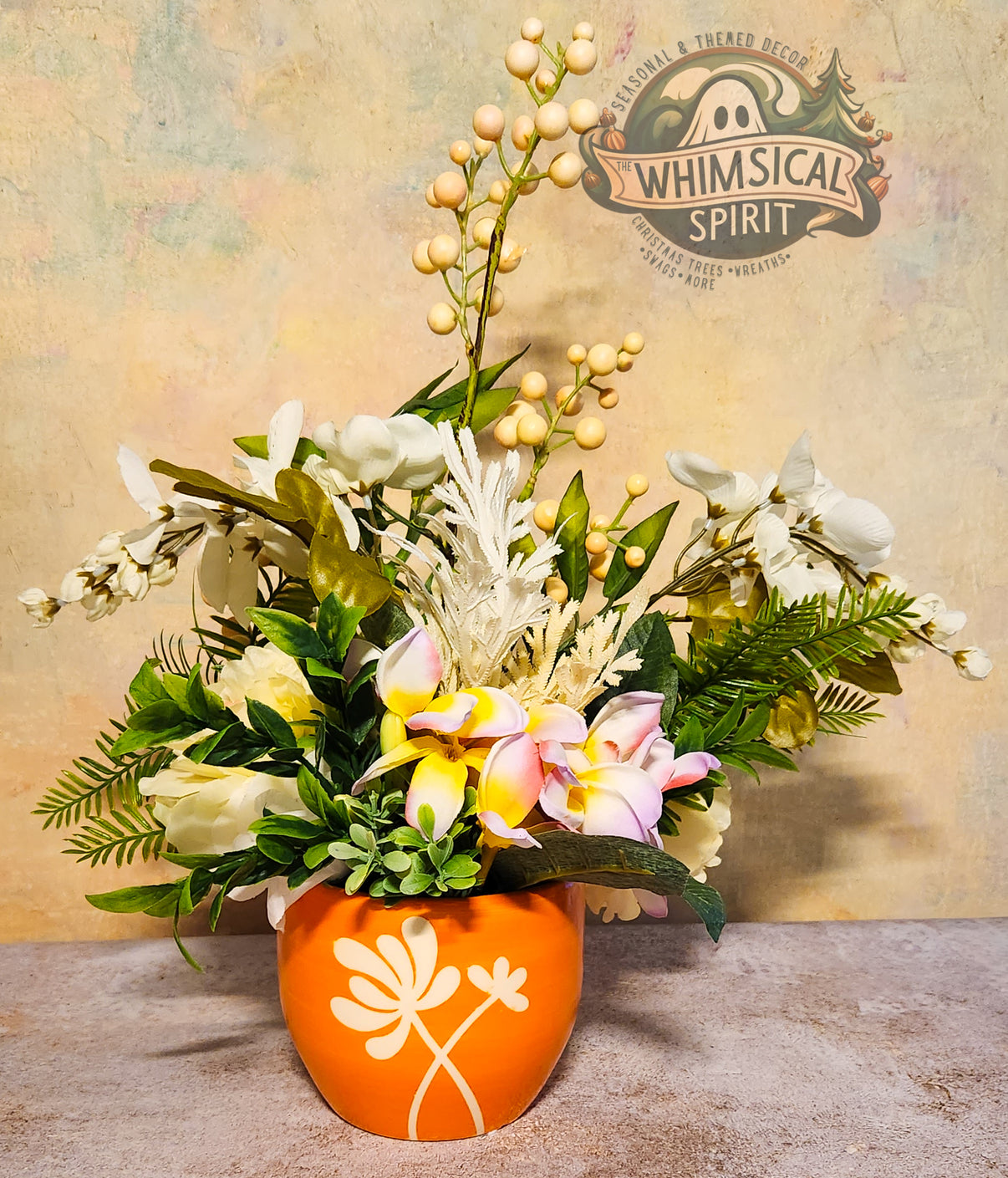 Floral arrangement in an orange pot with a decorative logo in the background