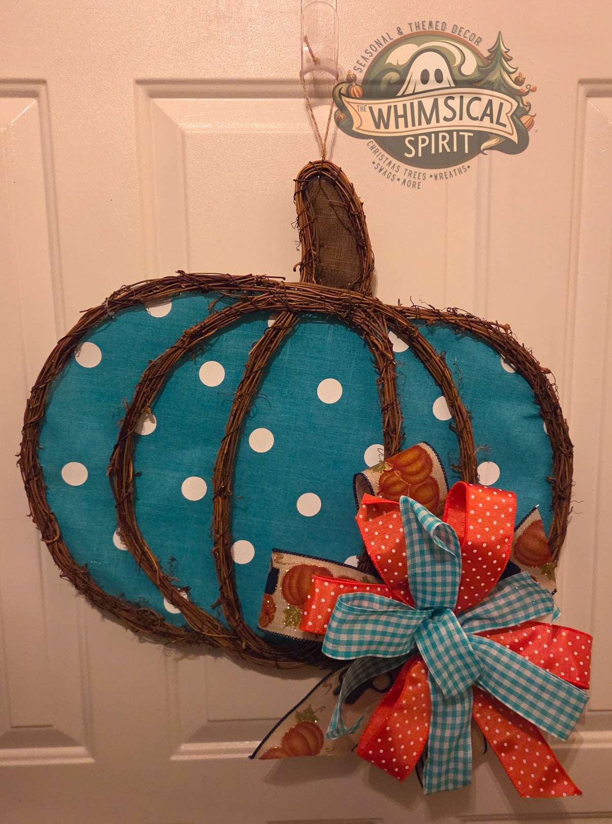 Grapevine blue pumpkin door hanger with white polka dots and layered fall bow hanging on front door