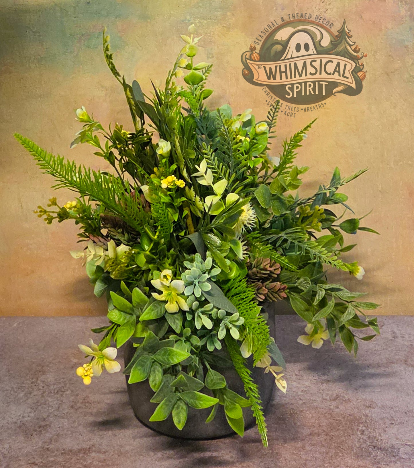 Artificial plant arrangement in a pot with 'Whimsical Spirit' branding on a textured background.