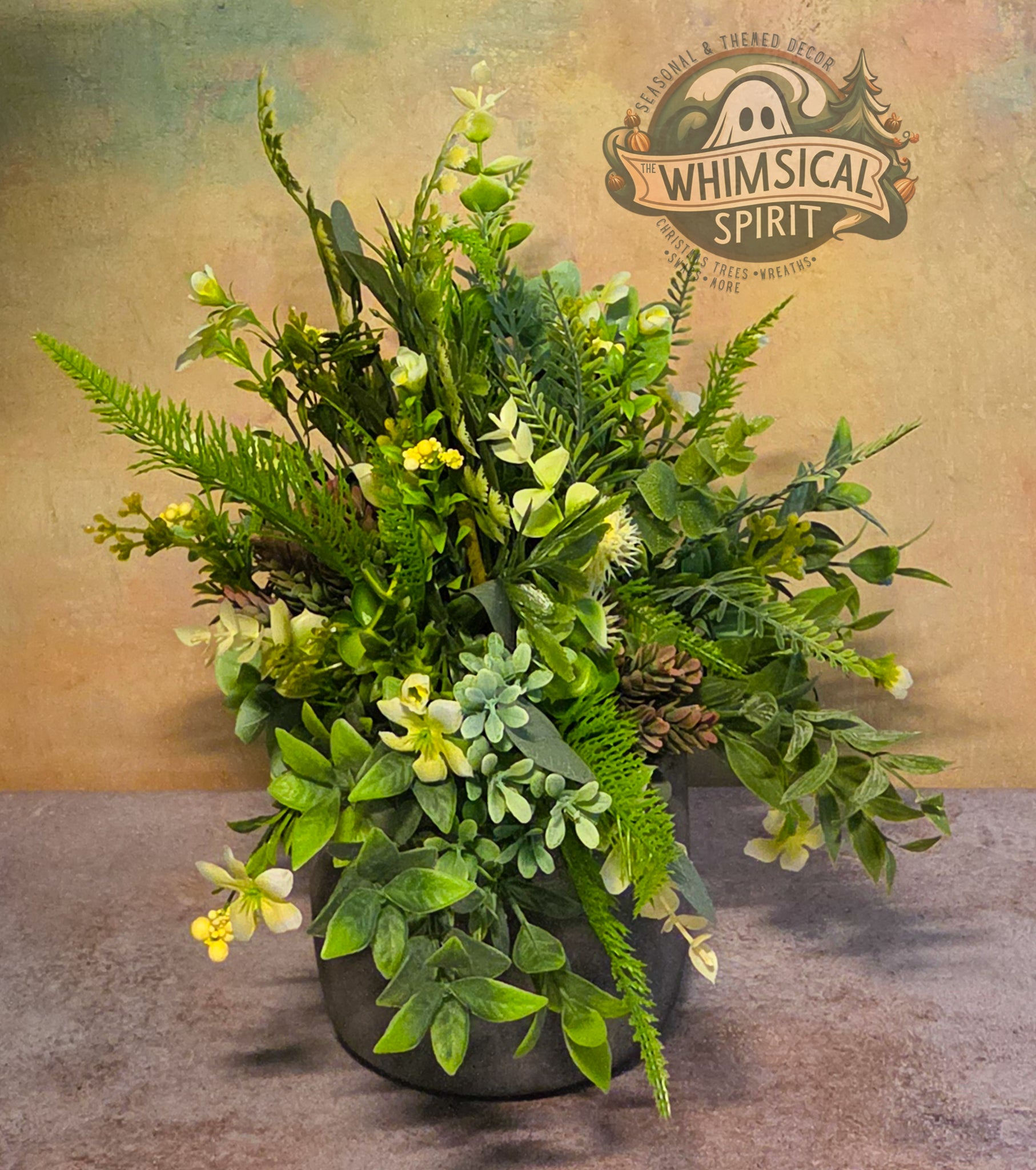 Artificial plant arrangement in a pot with 'Whimsical Spirit' branding on a textured background.