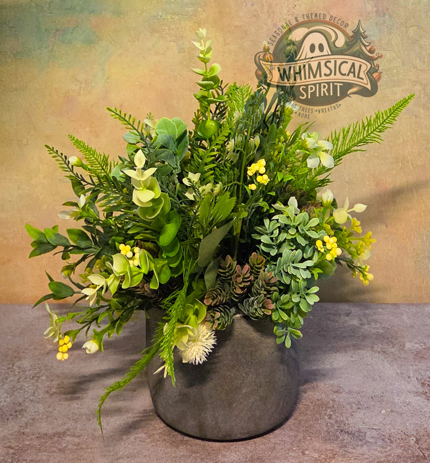 Artificial plant arrangement in a gray pot with 'Whimsical Spirit' branding in the background.