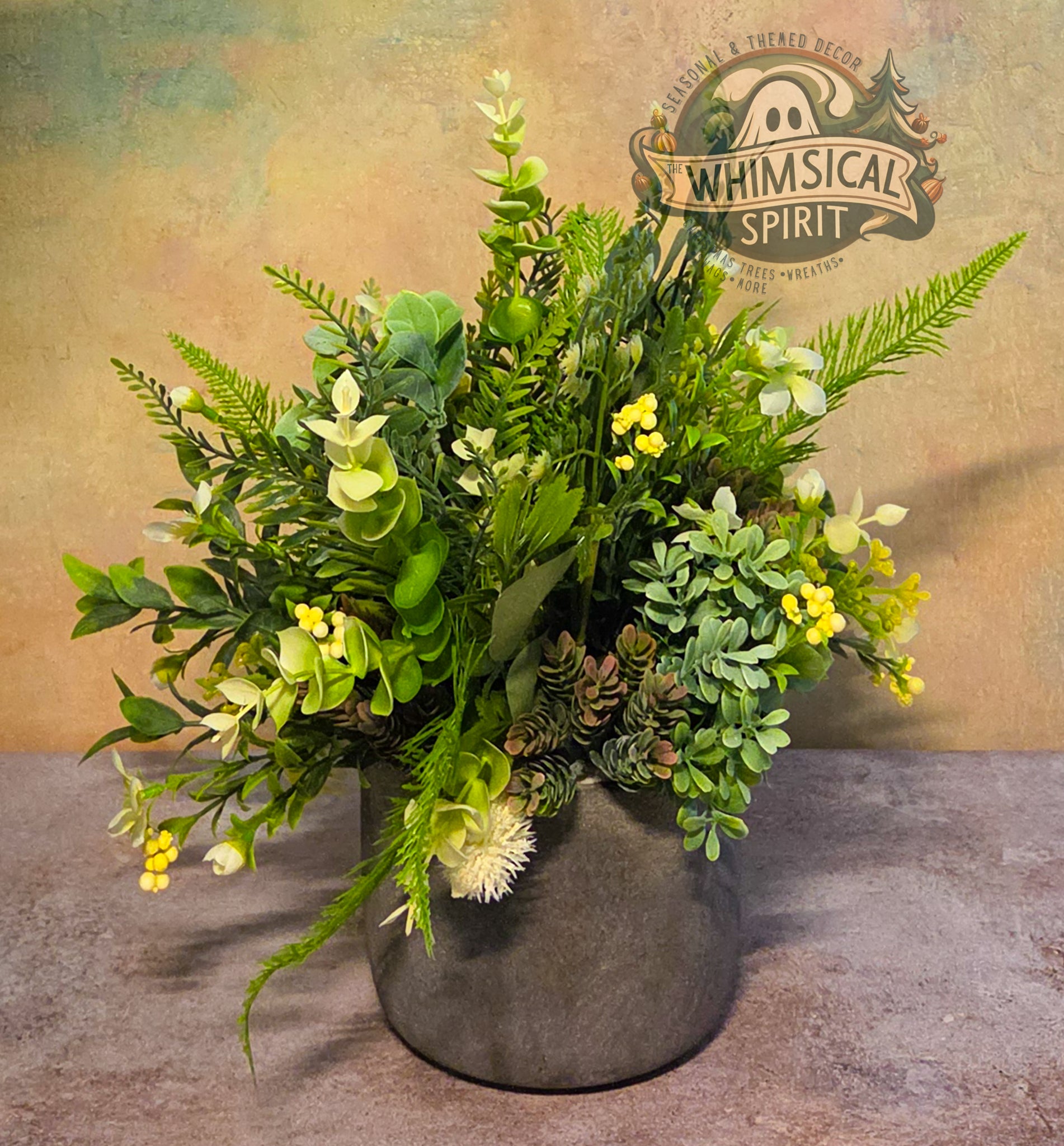 Artificial plant arrangement in a gray pot with 'Whimsical Spirit' branding in the background.