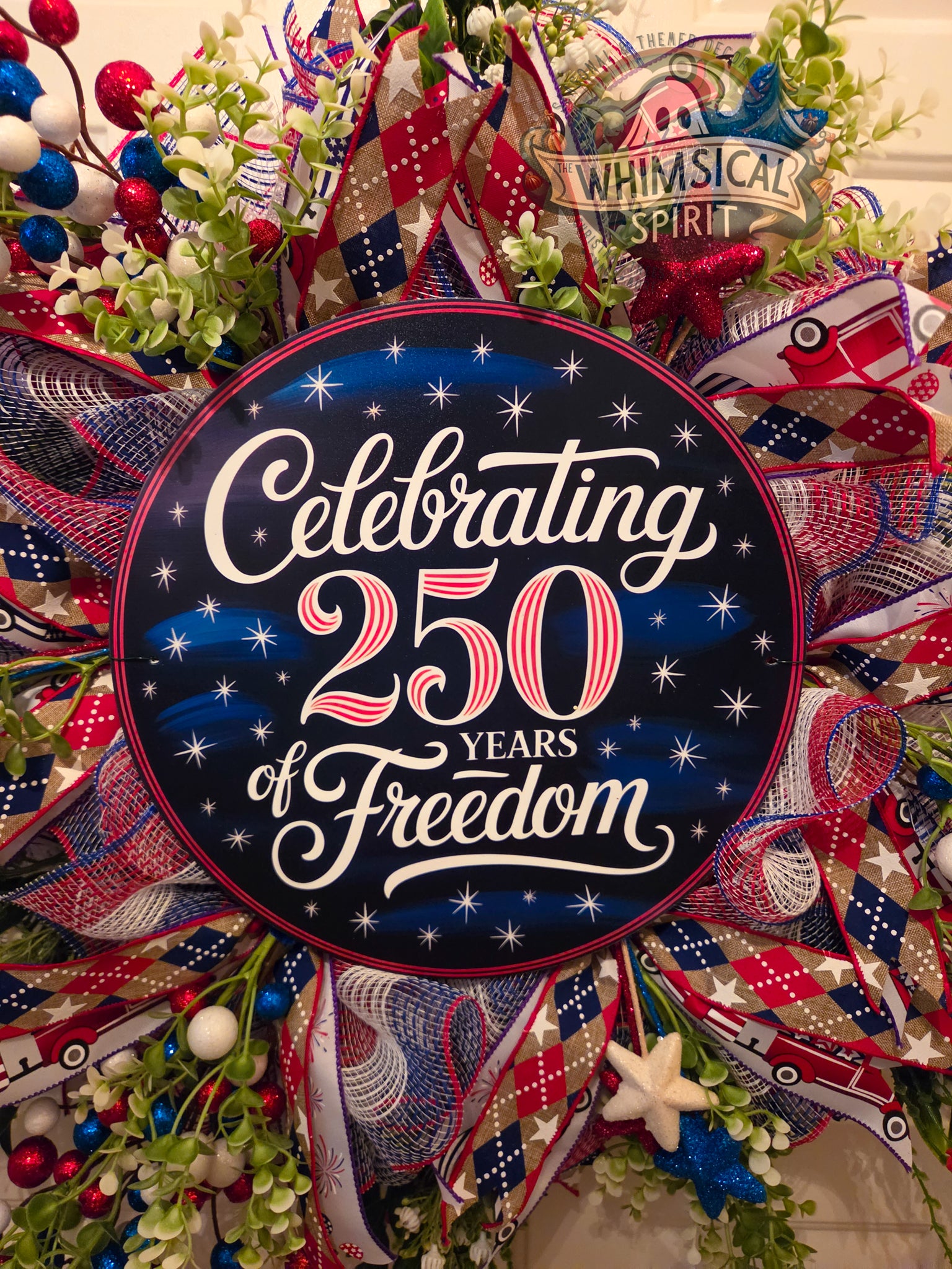 Decorative wreath with 'Celebrating 250 Years of Freedom' text and festive ribbons.