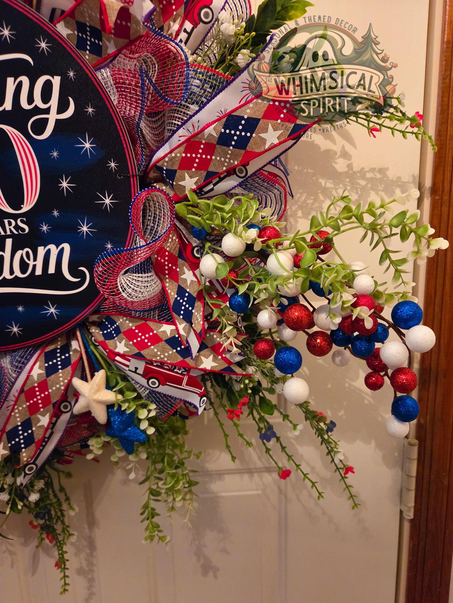 Decorative wreath with red, white, and blue ribbons and stars on a door.