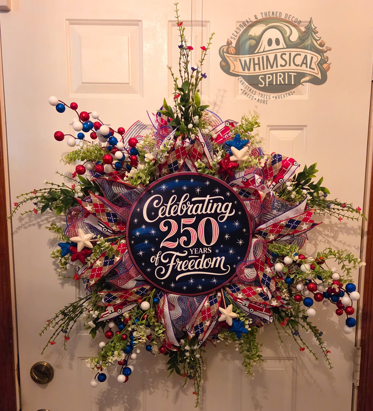 Decorative wreath with 'Celebrating 250 Years of Freedom' text on a door, branded 'Whimsical Spirit'.