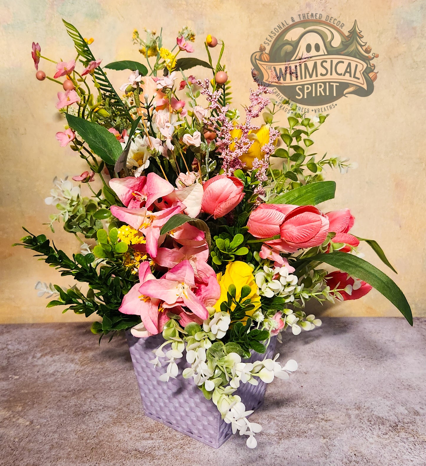 Floral arrangement in a decorative container with 'Whimsical Spirit' branding.