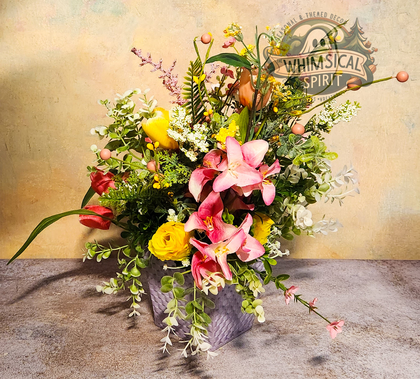 Colorful flower arrangement in a vase with 'Whimsical Spirit' branding on a textured surface.