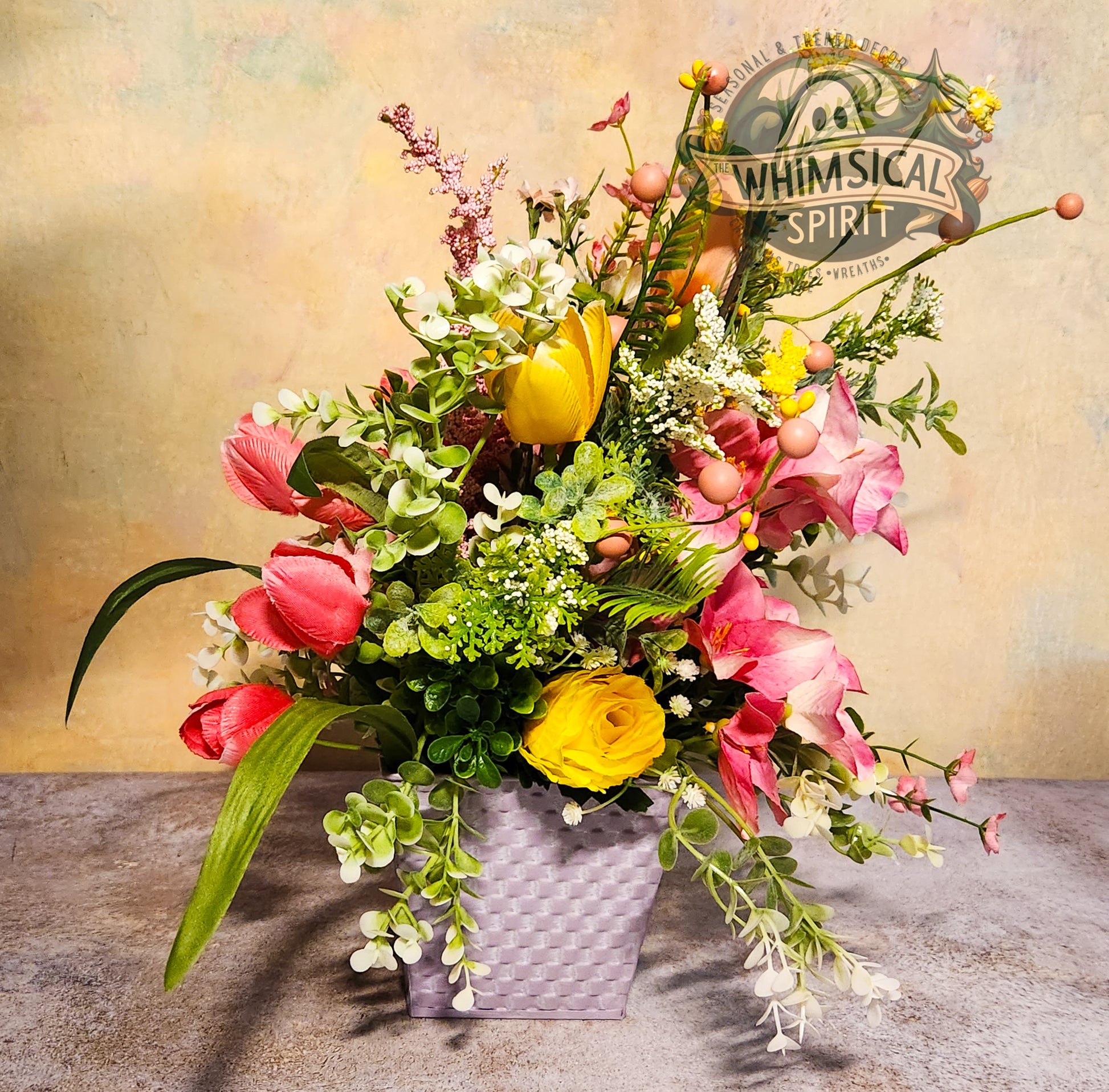 Colorful flower arrangement in a gray vase with 'Whimsical Spirit' branding.