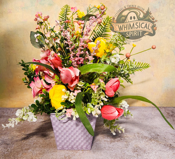 Colorful bouquet of flowers in a gray vase with 'Whimsical Spirit' branding in the background.