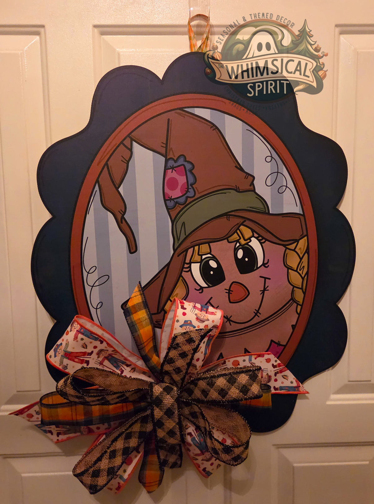 Hay There, Neighbor fall scarecrow birch wood door hanger with a black scalloped frame and large rustic patterned bow