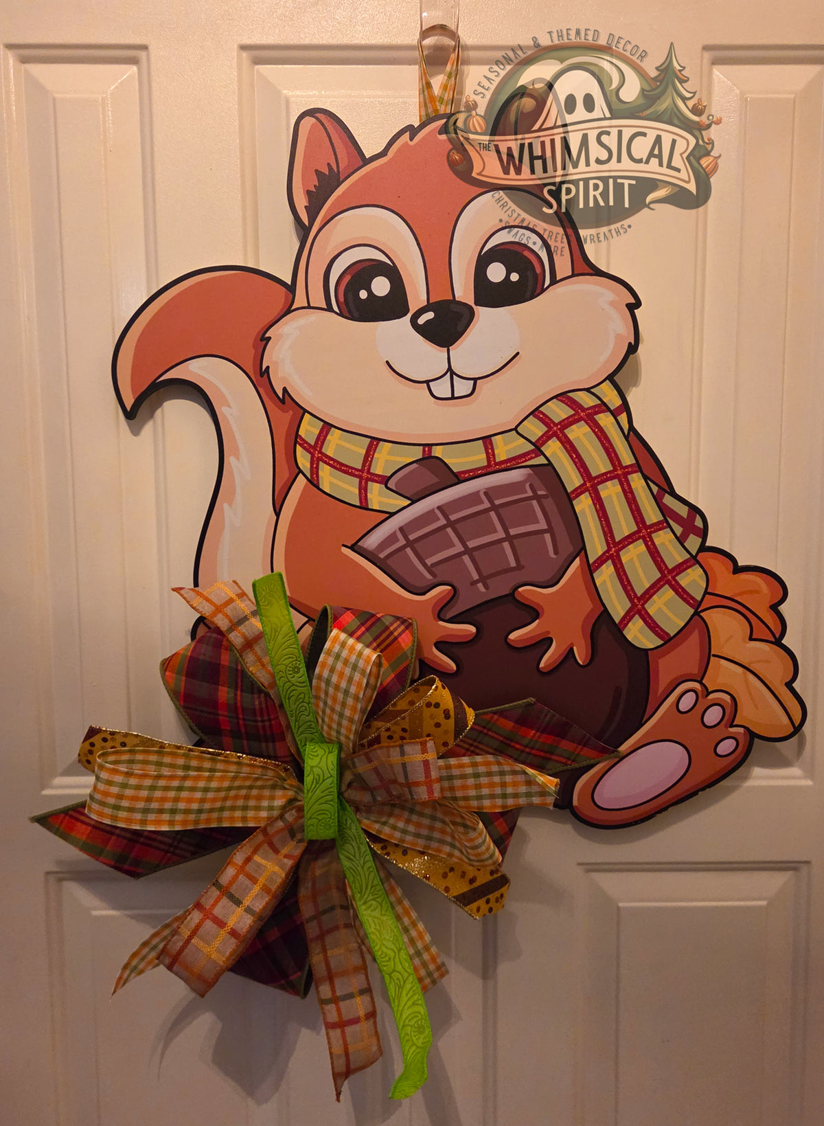 Hazel’s Acorn Haul birch wood fall door hanger with a scarf-wearing squirrel, oversized acorn, and large plaid bow