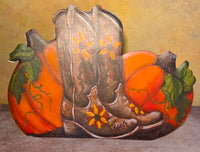 Kicking Up Autumn metal art featuring a pair of weathered brown cowboy boots surrounded by orange pumpkins, green leaves, and yellow flowers.
