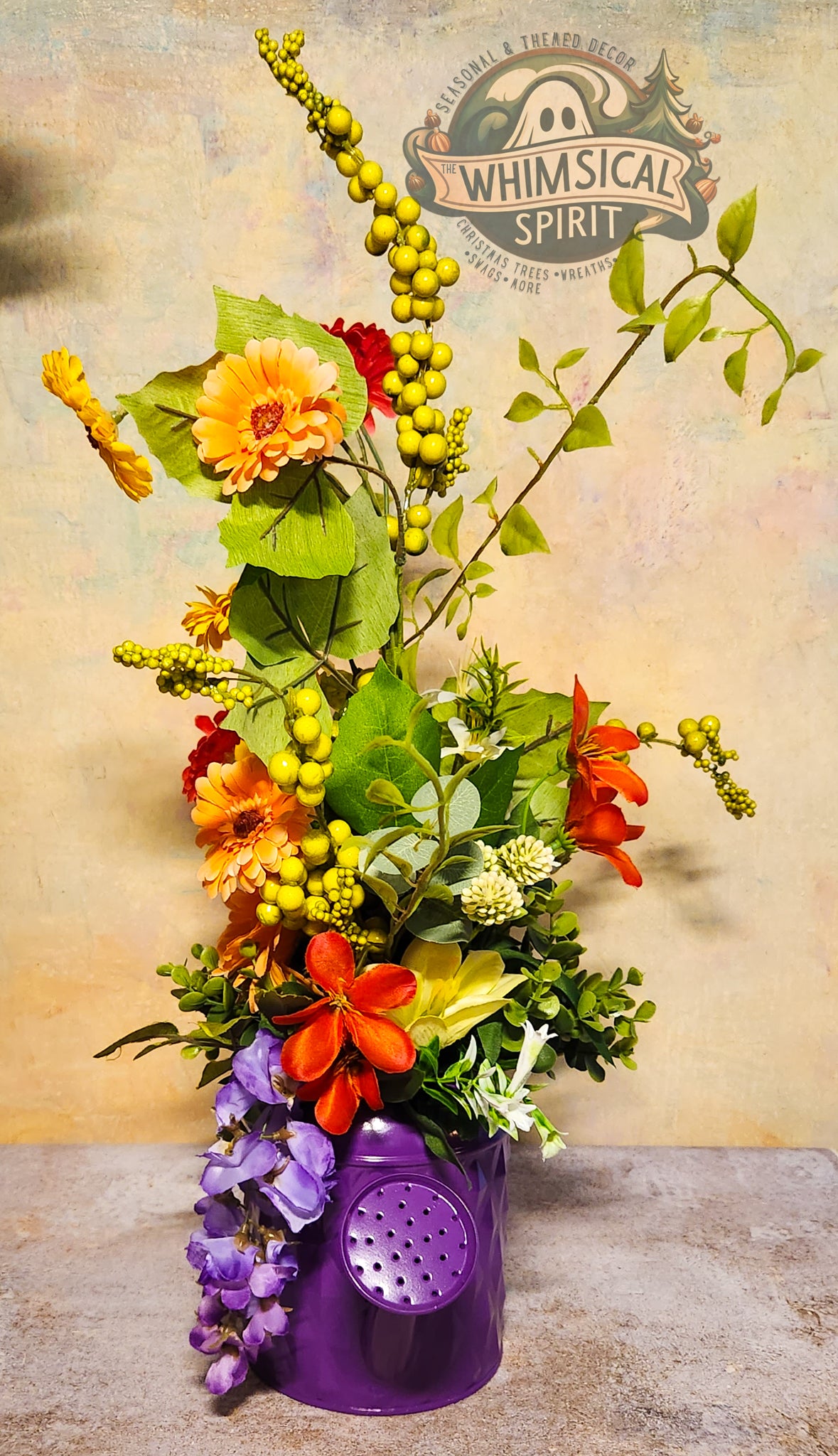 Colorful flower arrangement in a purple container with 'Whimsical Spirit' branding.