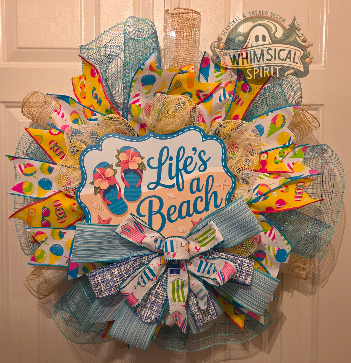 Decorative wreath with 'Life's a Beach' text and colorful design on a door.