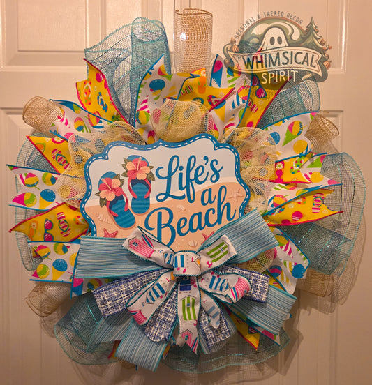 Decorative wreath with 'Life's a Beach' text and colorful design on a door.
