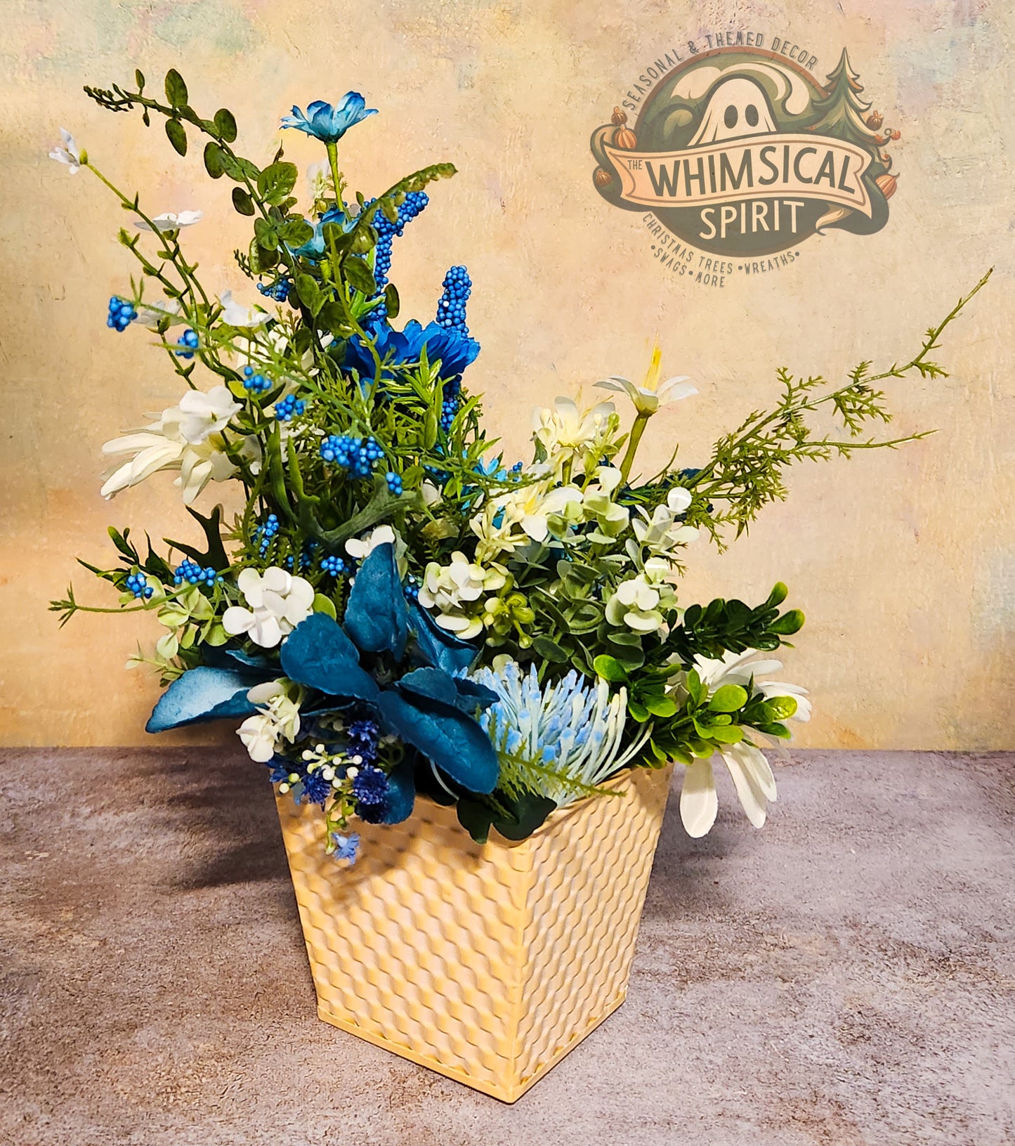 Floral arrangement in a woven basket with 'Whimsical Spirit' branding in the background.