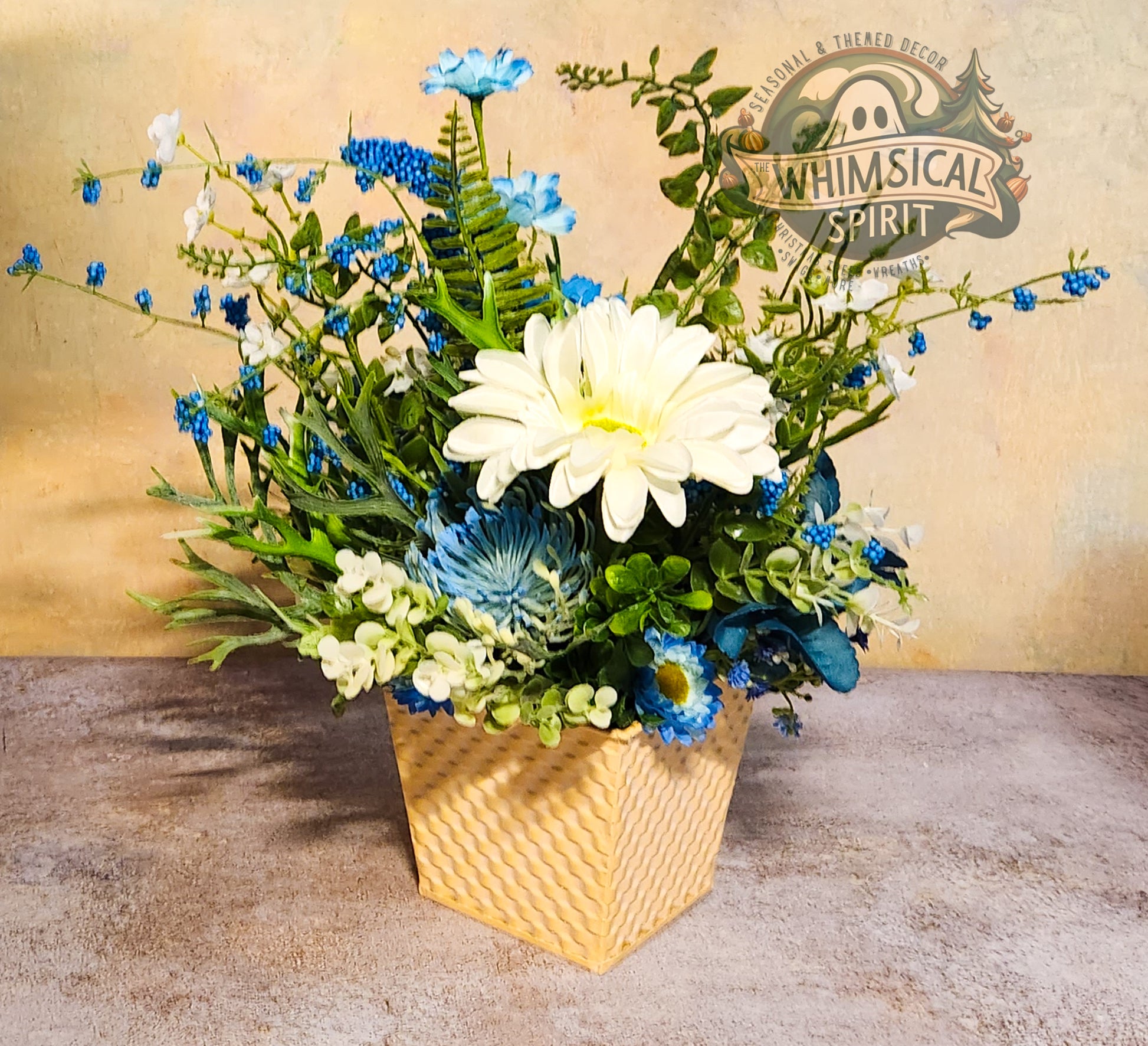 Floral arrangement in a woven basket with 'Whimsical Spirit' branding in the background.