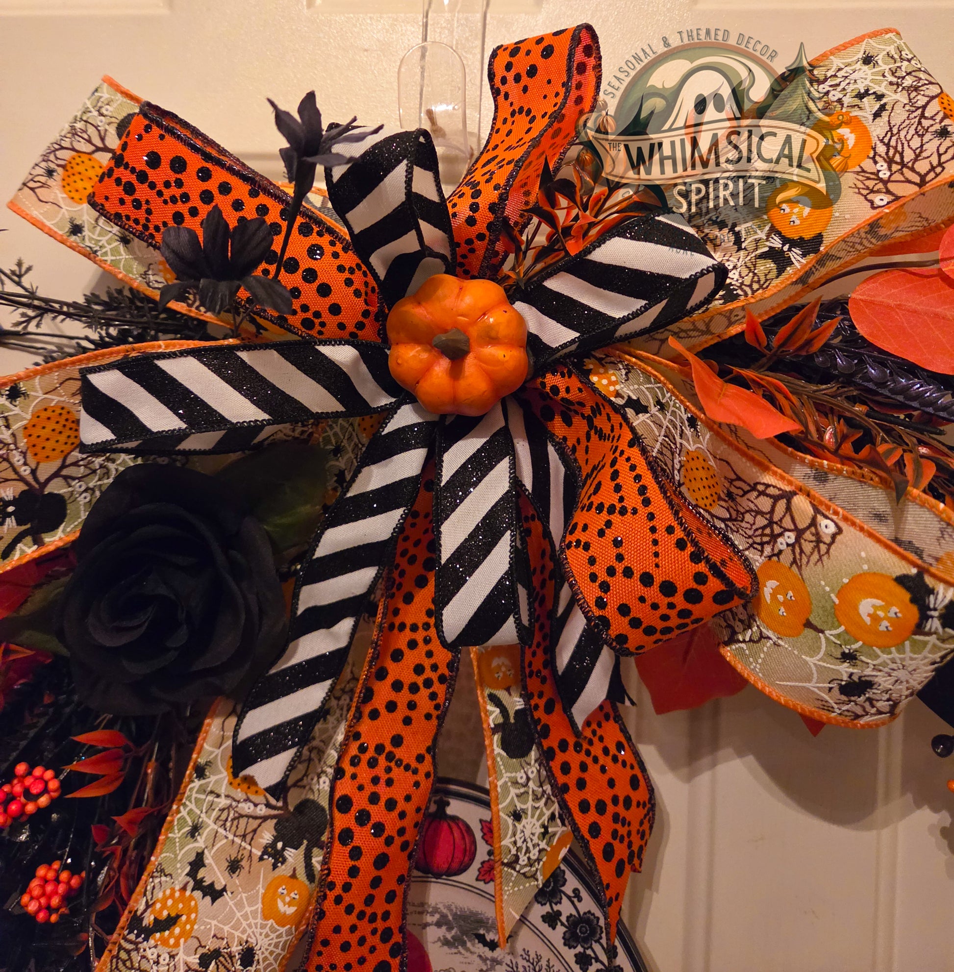 Halloween-themed decorative bow with orange, black, and white ribbons on a neutral background.