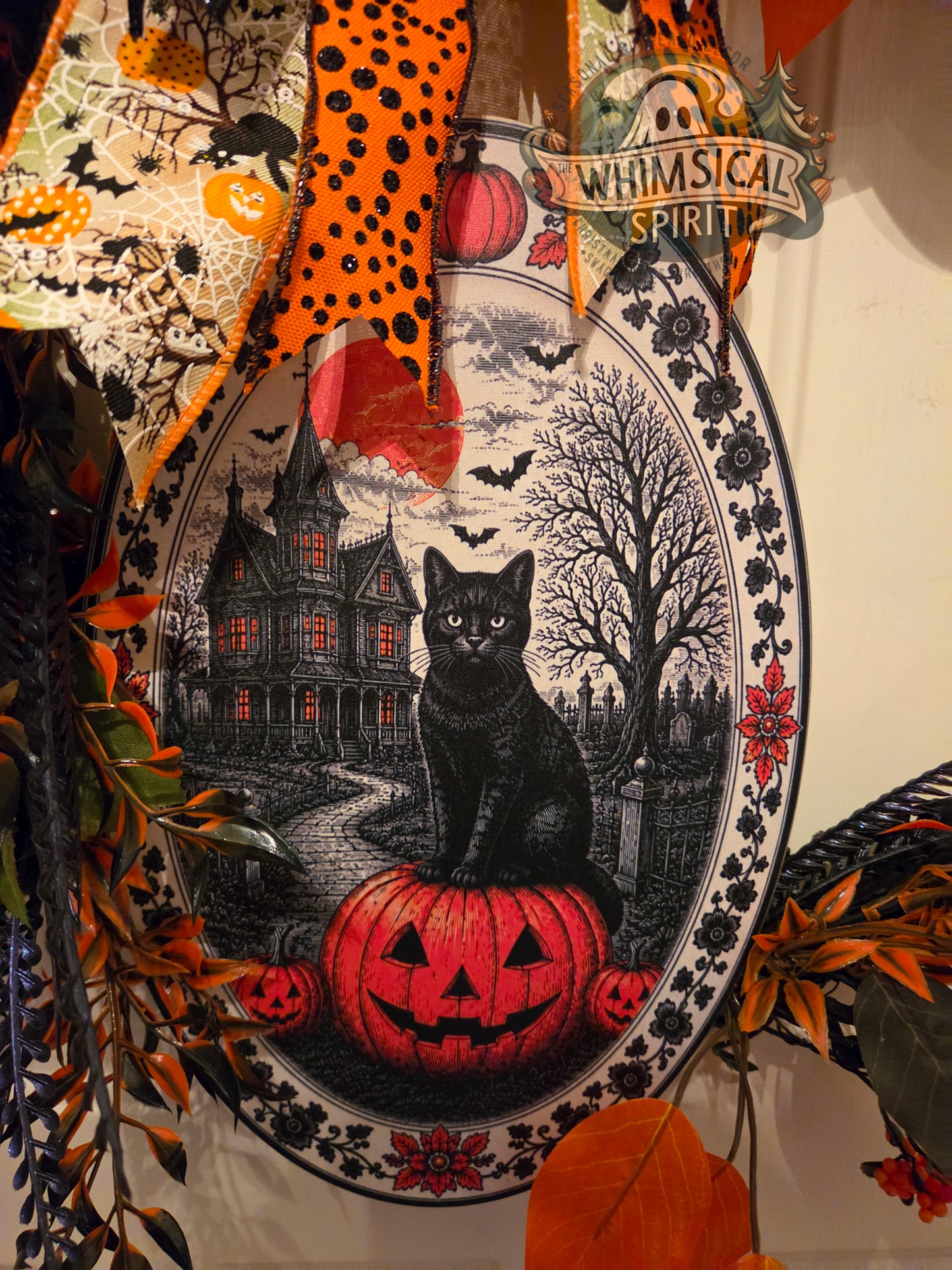 Decorative plate with Halloween theme featuring a black cat, pumpkin, and haunted house.