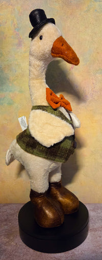 Front view of Mr. Waddlesworth plush fall goose shelf sitter wearing a black top hat, orange bow tie, green vest, and brown boots.