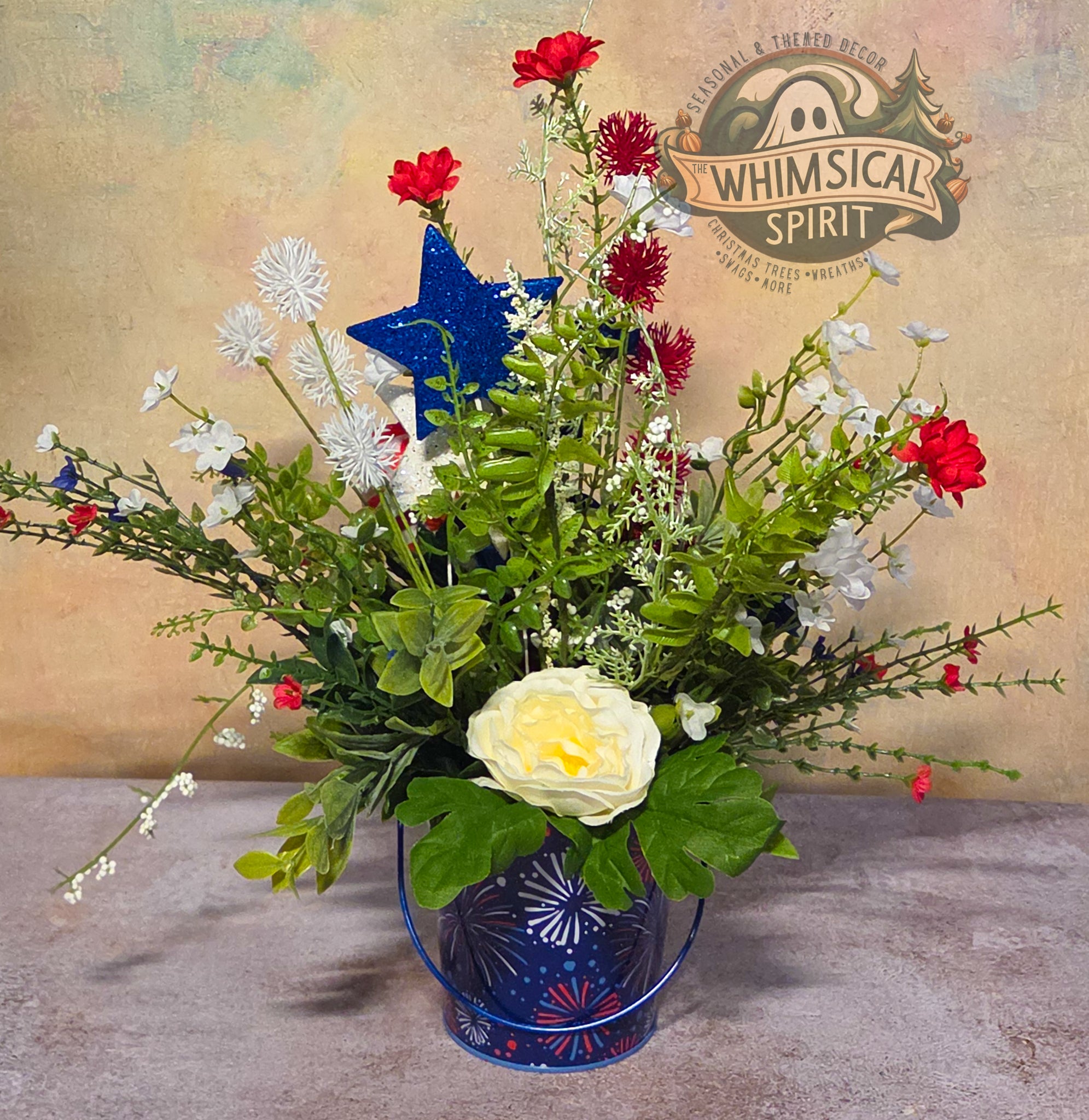 Floral arrangement with a blue star in a blue vase on a textured surface, branded 'Whimsical Spirit'.
