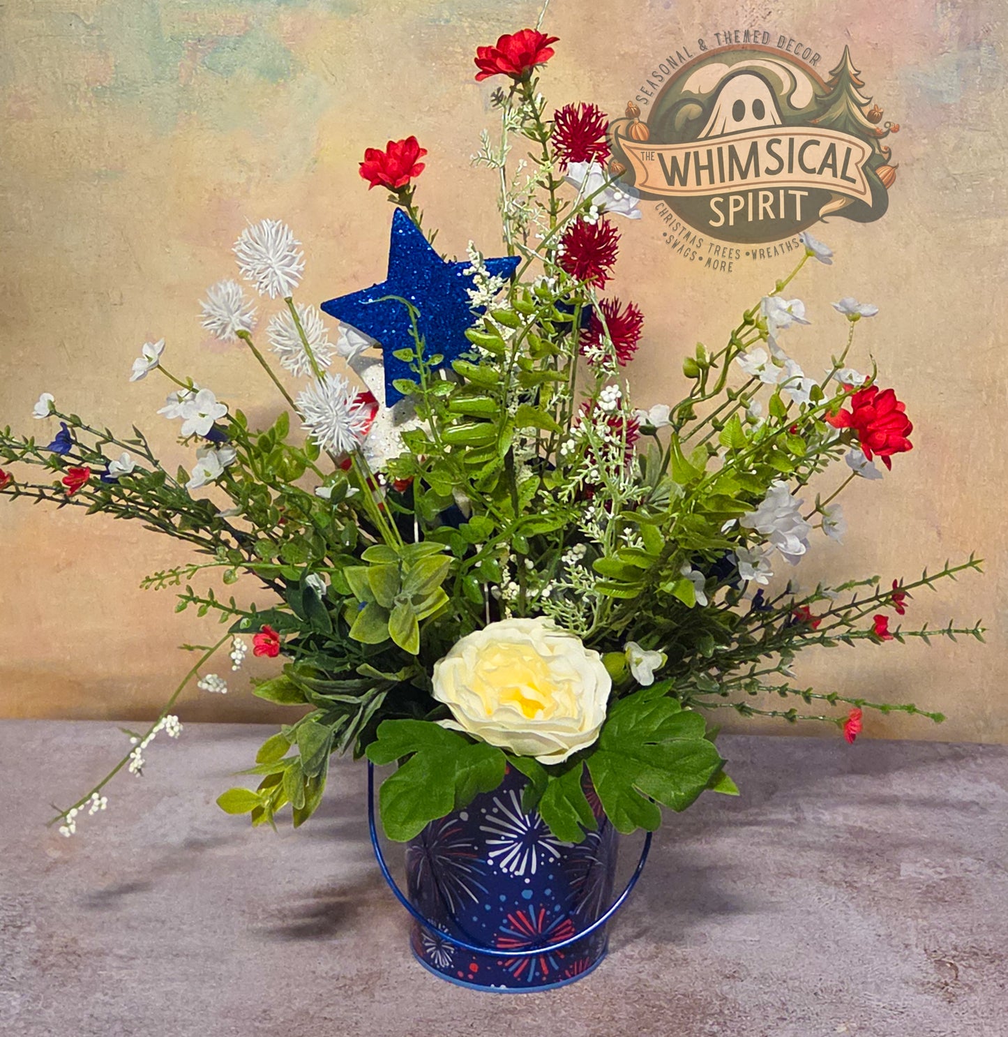 Floral arrangement with a blue star in a blue vase on a textured surface, branded 'Whimsical Spirit'.