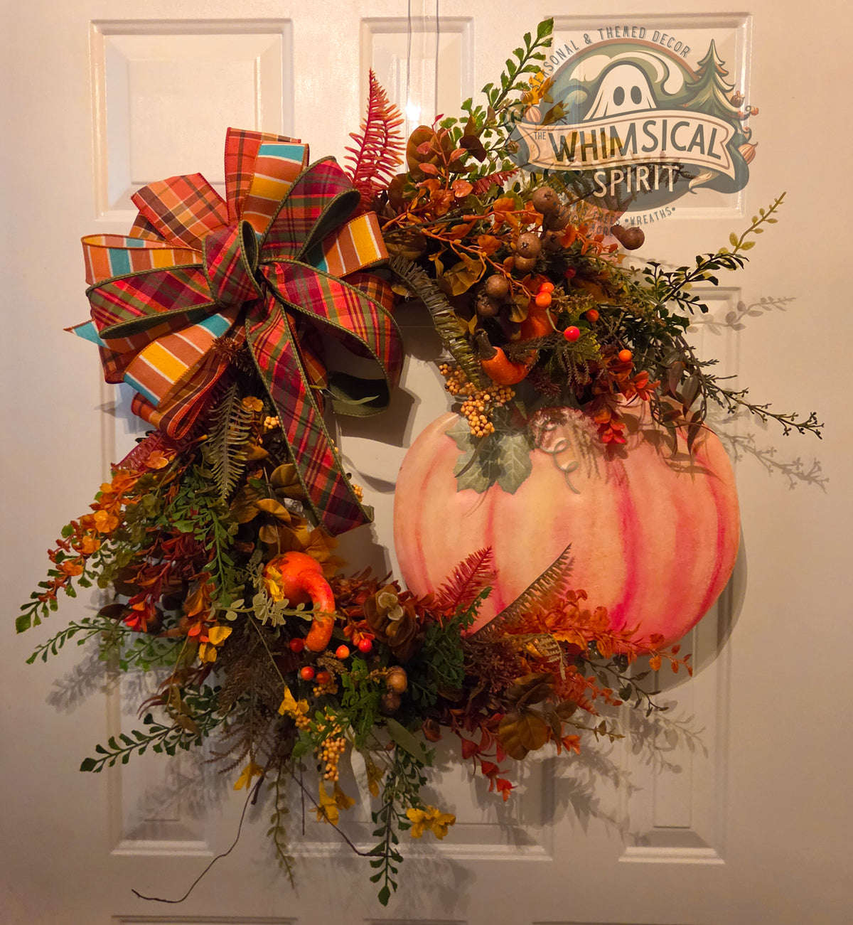 Plaid, Pumpkins & Autumn Skies fall grapevine wreath with a peach pumpkin, autumn greenery, berries, miniature pumpkins, and layered plaid bow.