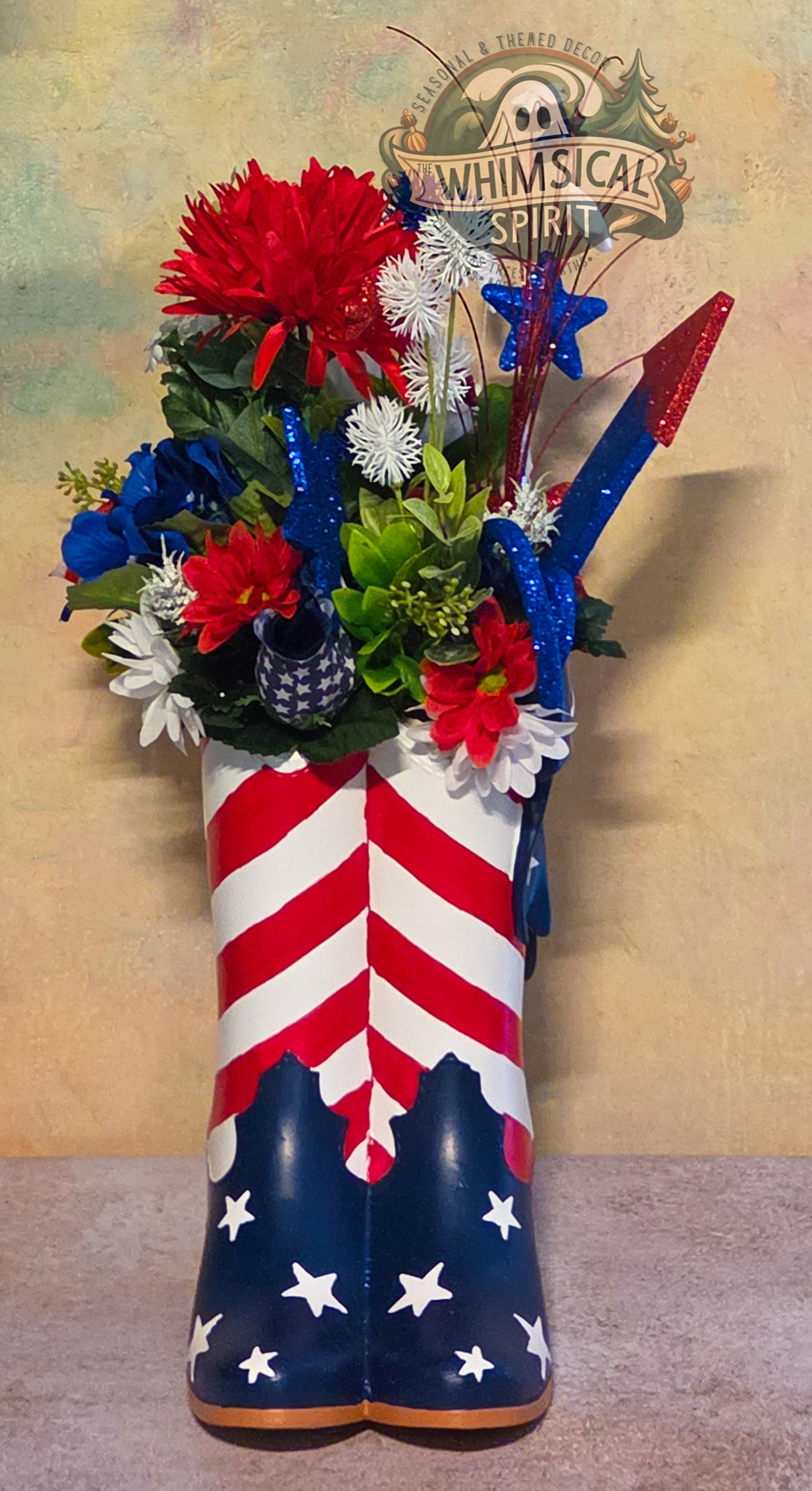 Decorative boot with American flag design filled with flowers, branded 'Whimsical Spirit'.
