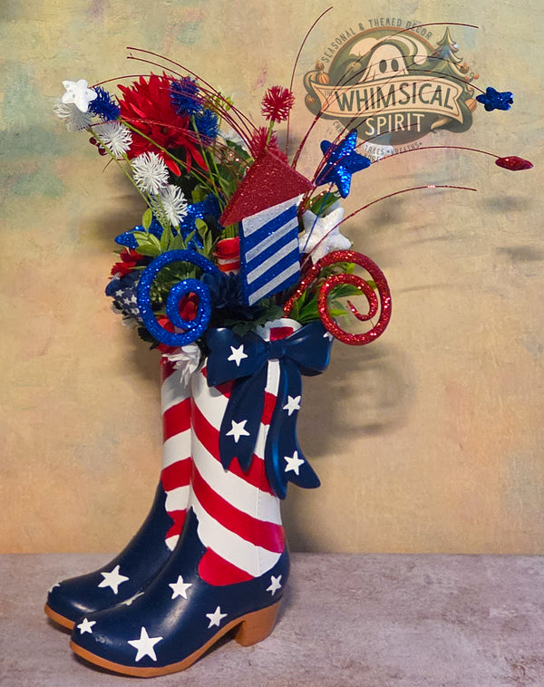 Decorative arrangement with American flag-themed boots and flowers on a textured background.