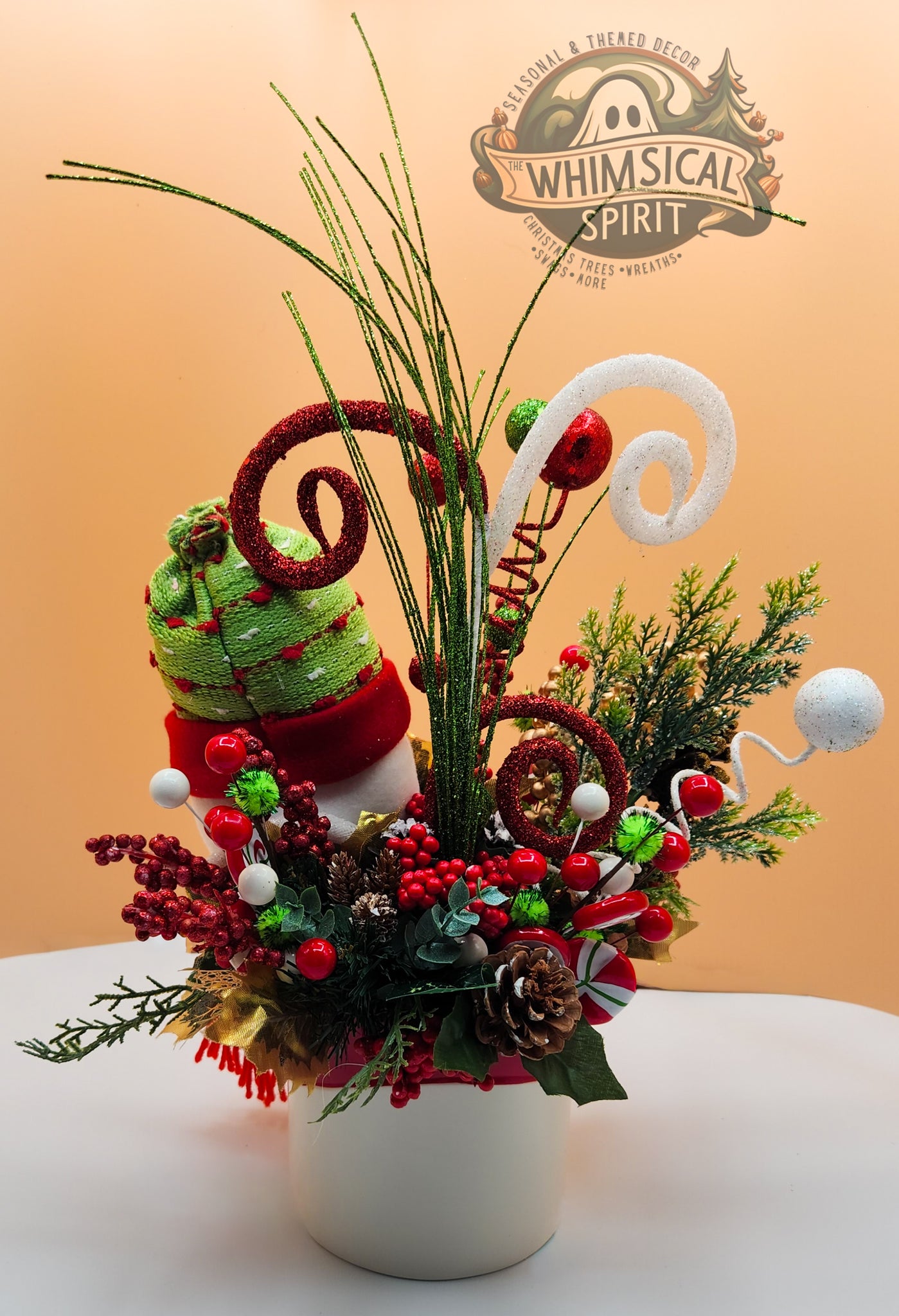 Festive Christmas floral arrangement with candy canes and 'Whimsical Spirit' logo. SEO-optimized holiday centerpiece.