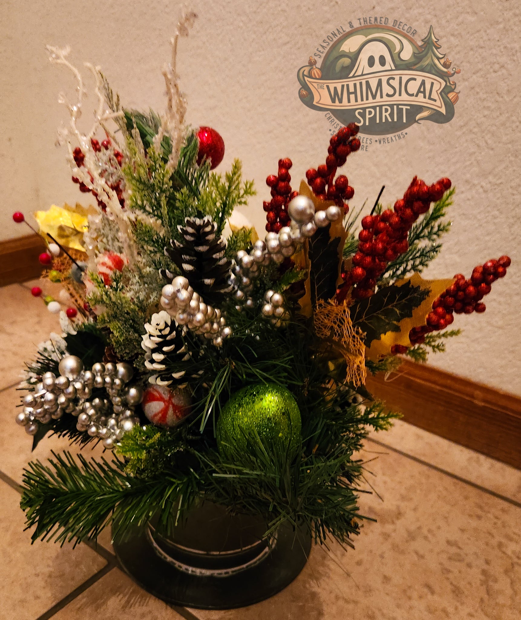 Decorative Christmas arrangement featuring greenery, red berries, and pinecones on a neutral background