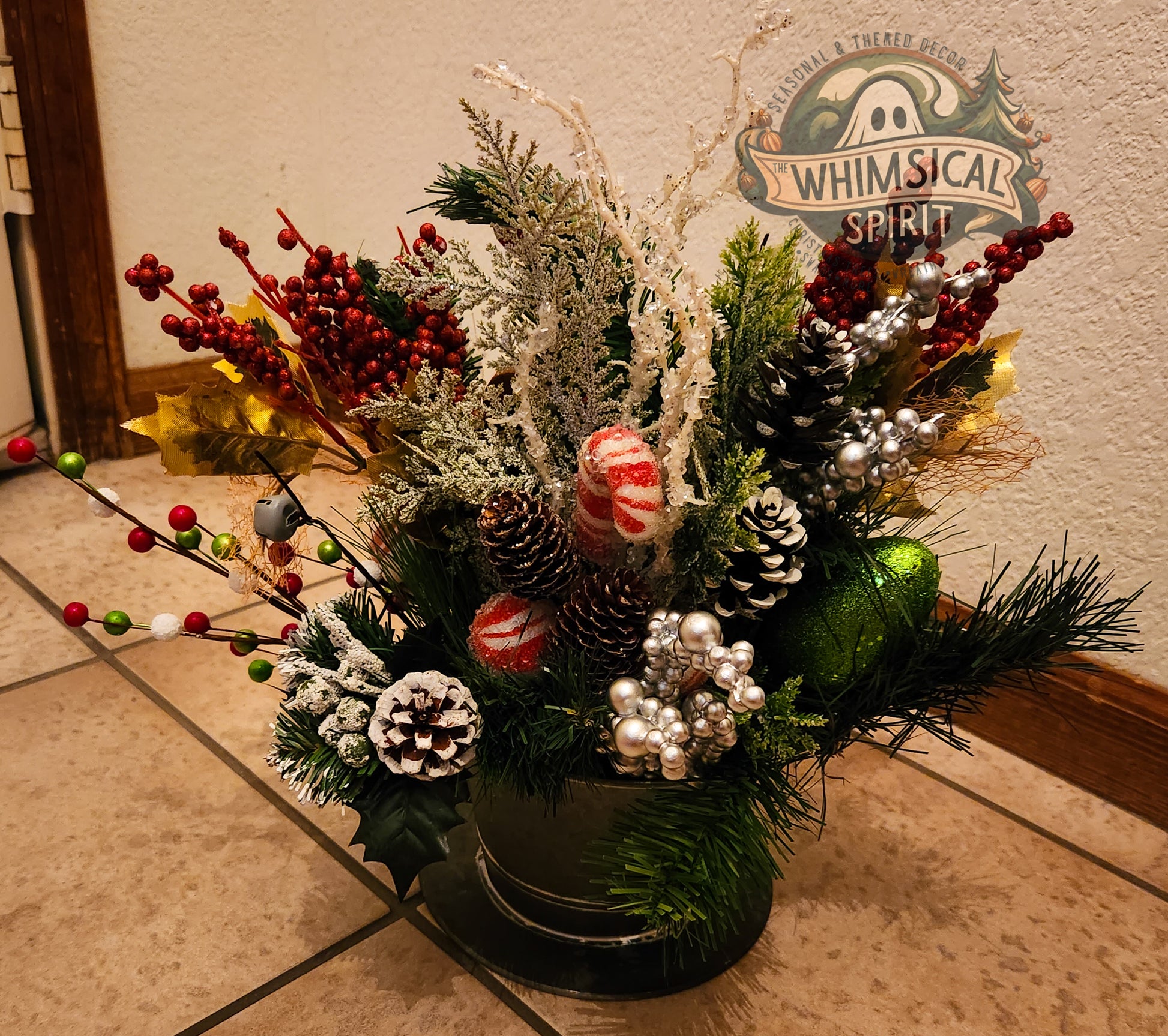 Decorative Christmas flower arrangement with pine cones and berries on a tiled floor.
