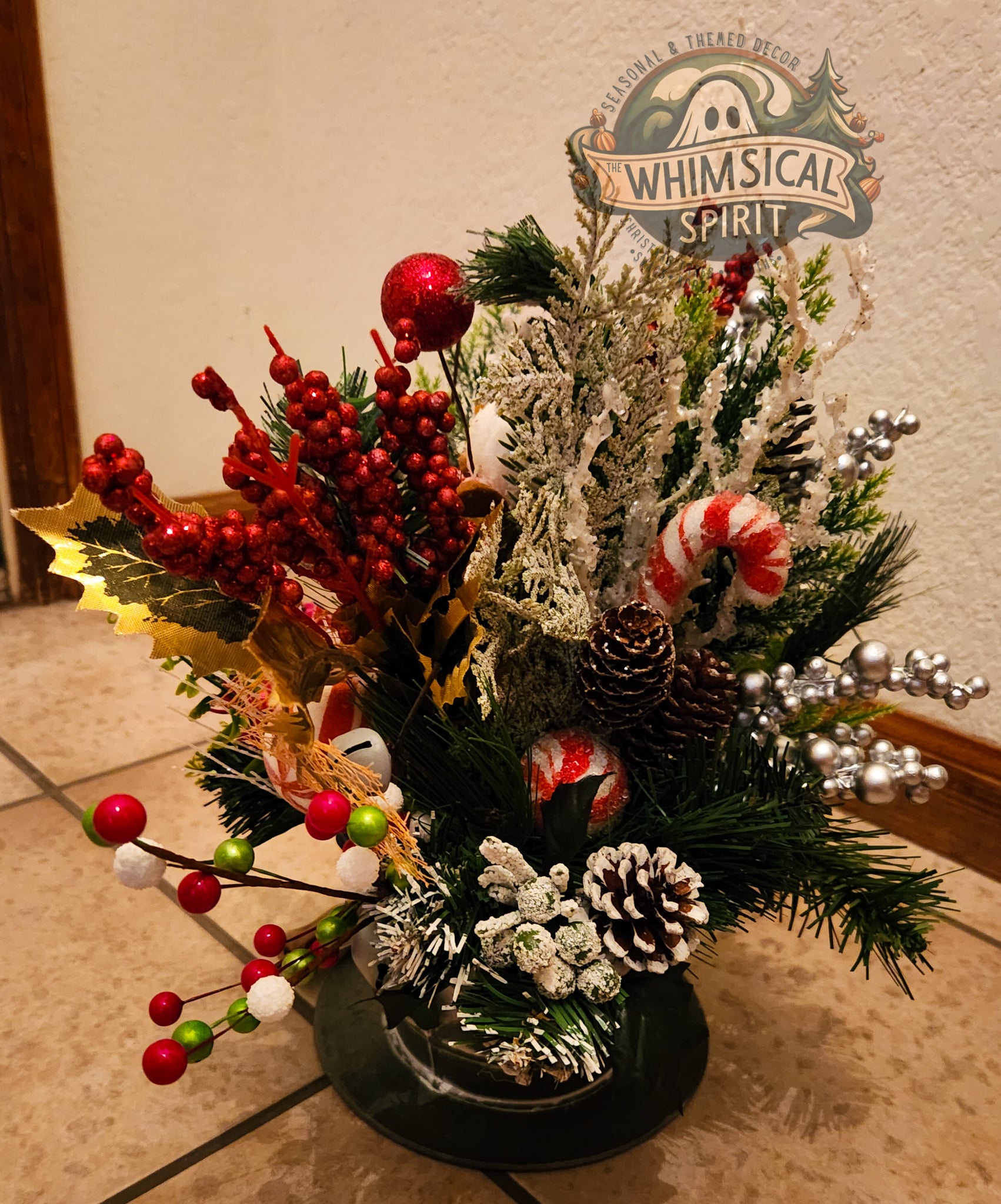 Christmas arrangement with red berries, candy canes, and pinecones.